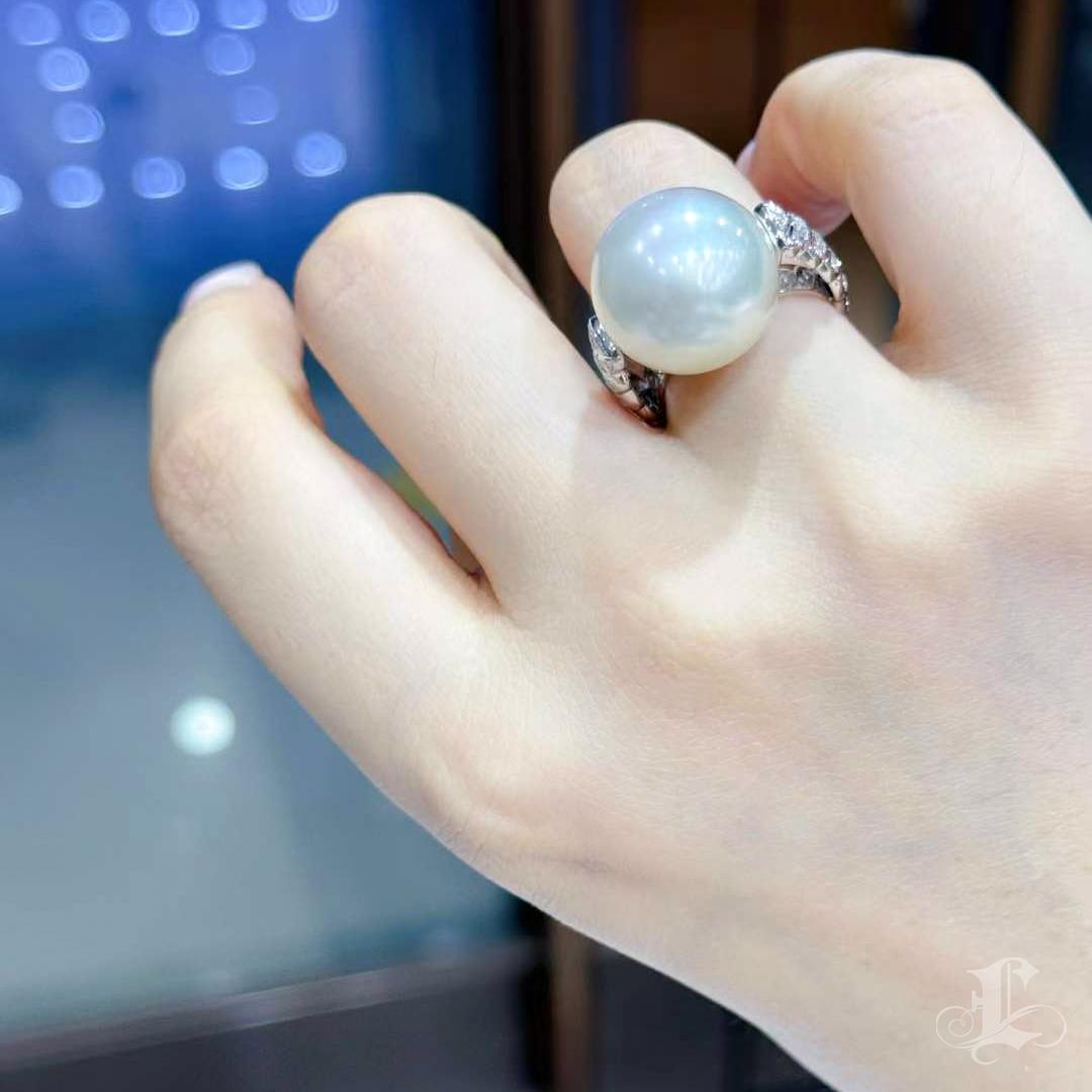 This stunning ring showcases a 16mm Aurora South Sea pearl, celebrated for its baby-soft, exquisite nacre. Paired with a minimalist ring base, this design emphasizes the pearl’s exceptional quality, creating a timeless elegance. Perfect for any