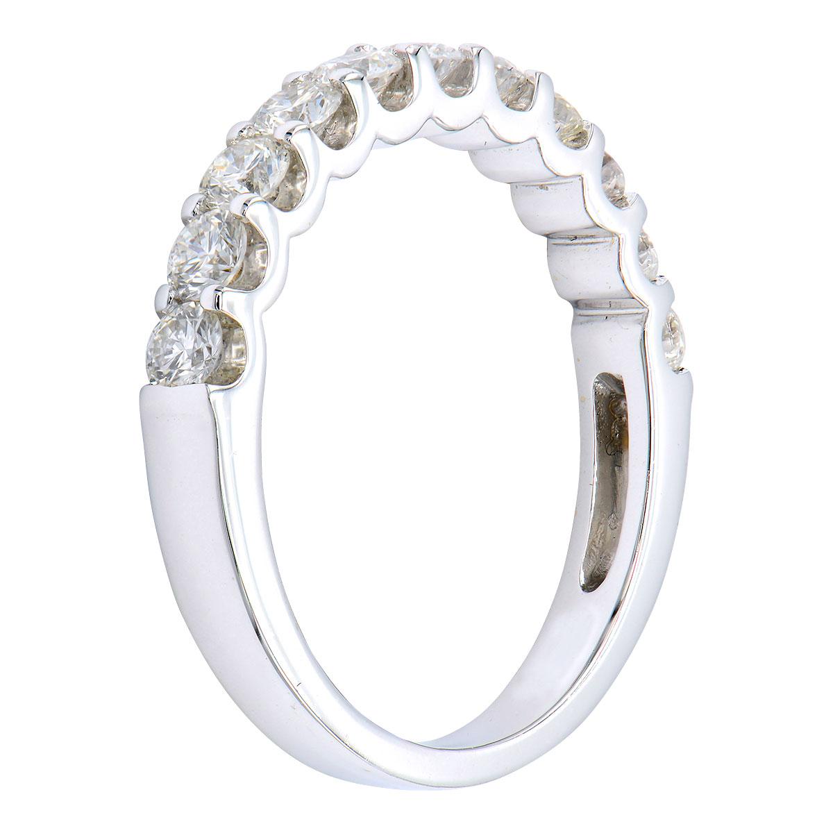 This stunning modern take on a classic diamond band is made from 2.9 grams of 18 karat white gold. Set in the gold are 11 round VS2, G color diamonds totaling 0.88 carats which go halfway around the band. From the side of the ring, the prongs are