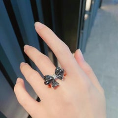 Bague en or blanc 18K en forme de noeud avec diamants et diamants noirs