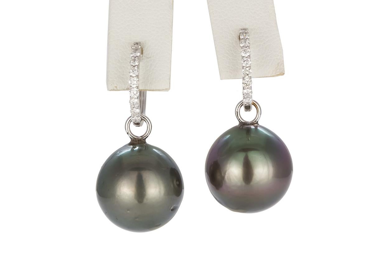 We are pleased to present these Ladies 18k White Gold Diamond & Black Tahitian Pearl Earrings. This cute set of earrings features a pair of 16mm Black Tehitian pearls with 18k white gold and diamond hoop earrings set with with three 0.36ctw