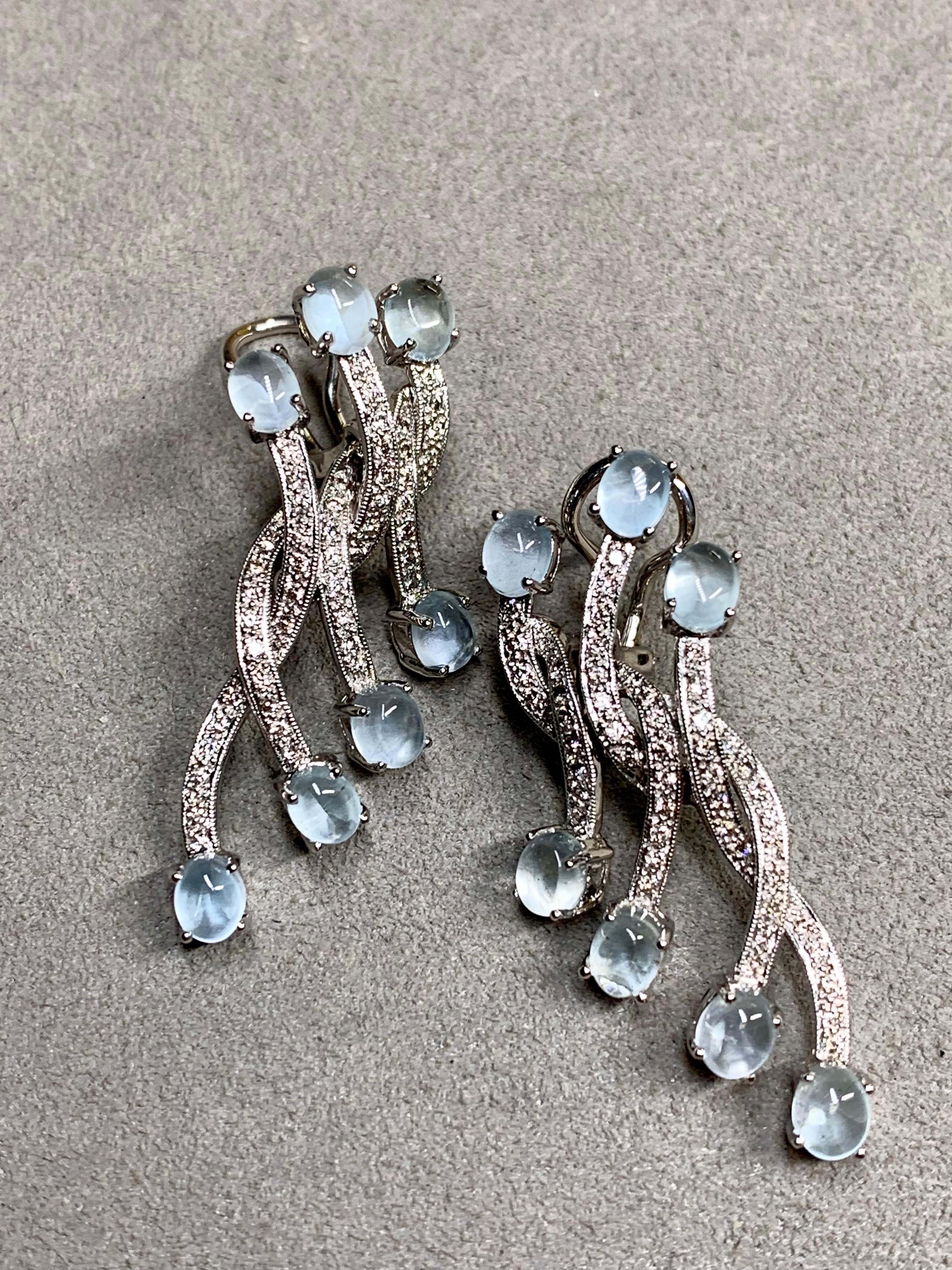 Une belle paire de boucles d'oreilles contemporaines très bien réalisées en or blanc 18 carats. Elles sont serties d'environ 0,70ctw de diamants ronds de couleur G-H et de pureté Vs1-2 ainsi que de 7,50ctw de cabochons d'aigue-marine naturelle. Ils