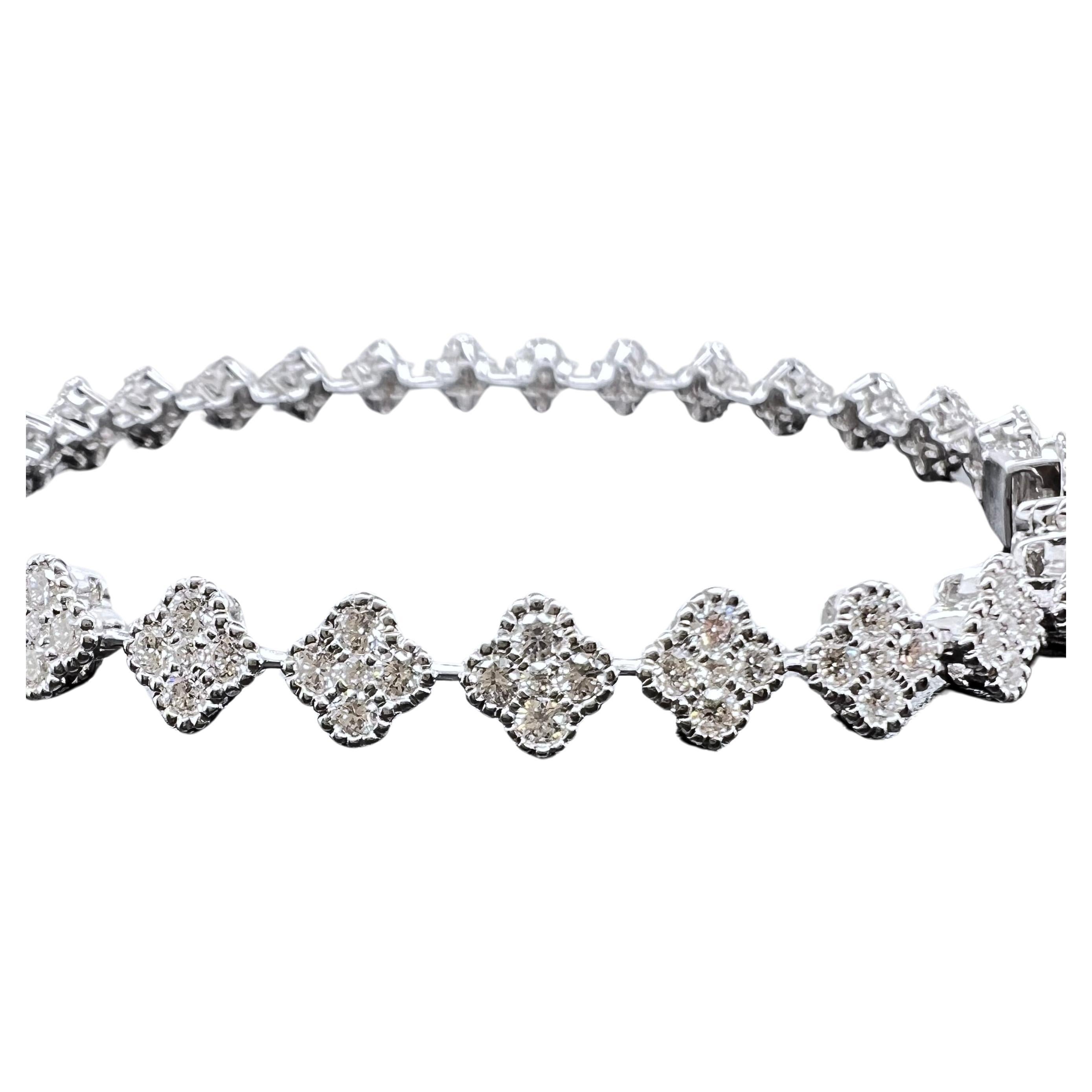 Questo è assolutamente uno dei nostri braccialetti impilabili preferiti.  Incastonato in oro bianco 18 carati, il braccialetto tennis stile trifoglio è perfetto da aggiungere a qualsiasi pila o può essere indossato da solo.  I diamanti tondi