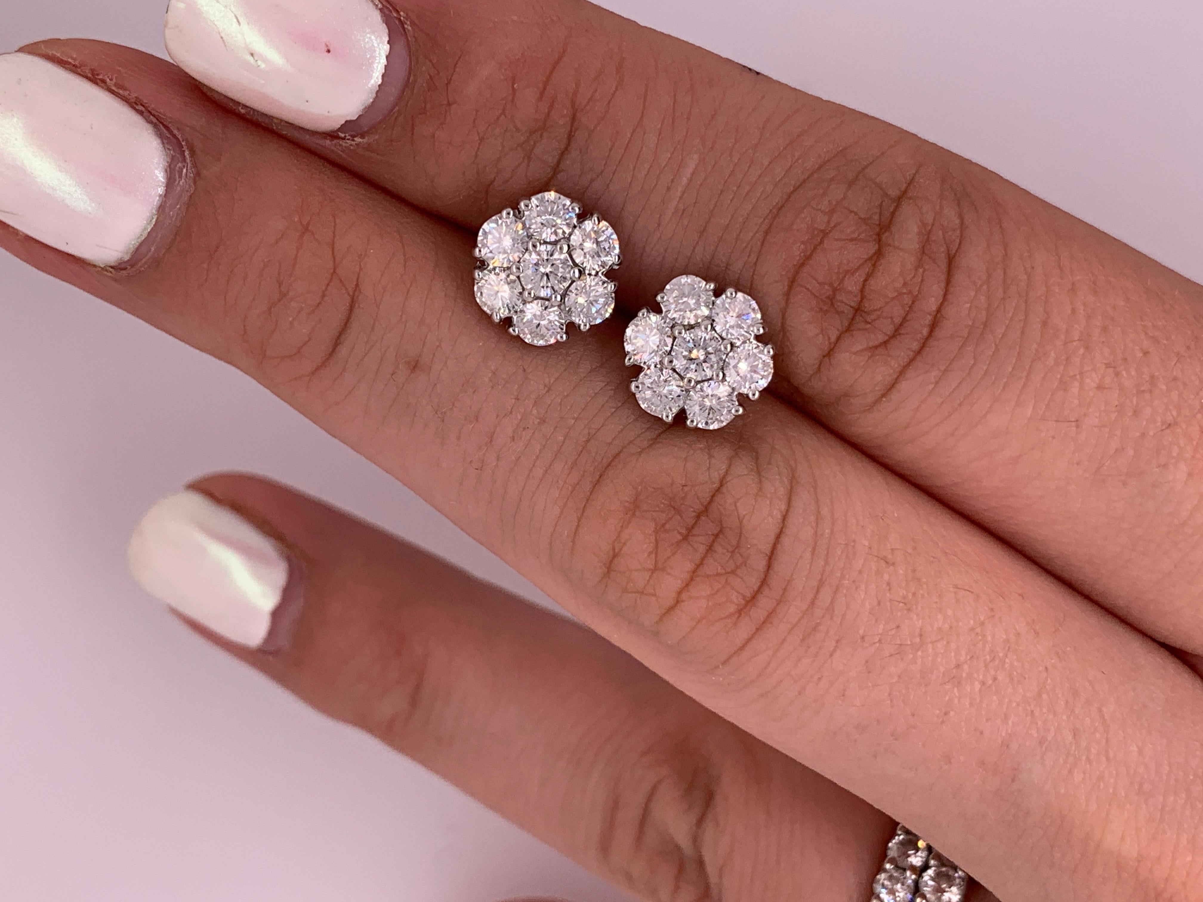 18K White Gold diamond cluster earrings features 1.80 carats of round brilliant cut diamonds. 14 brilliant cut diamonds each stone approximately 0.12 carats. 
