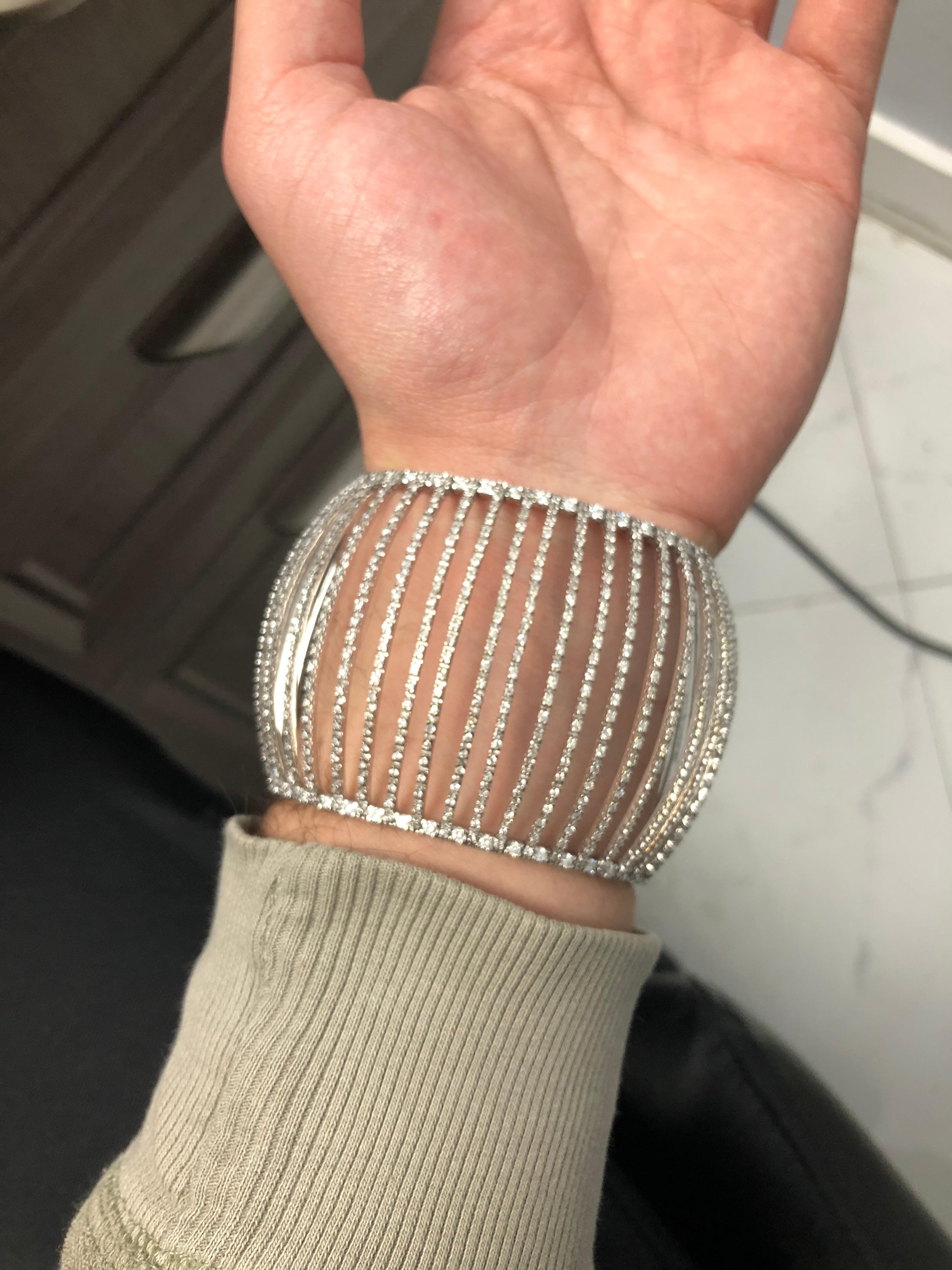 The cuff bangle features round-cut diamonds weighing a total of approximately 5.79 carats, set in 18K white gold.

Stones: Diamond ~ 5.79 carats

Metal: 18K White Gold

Size: 2 1/4