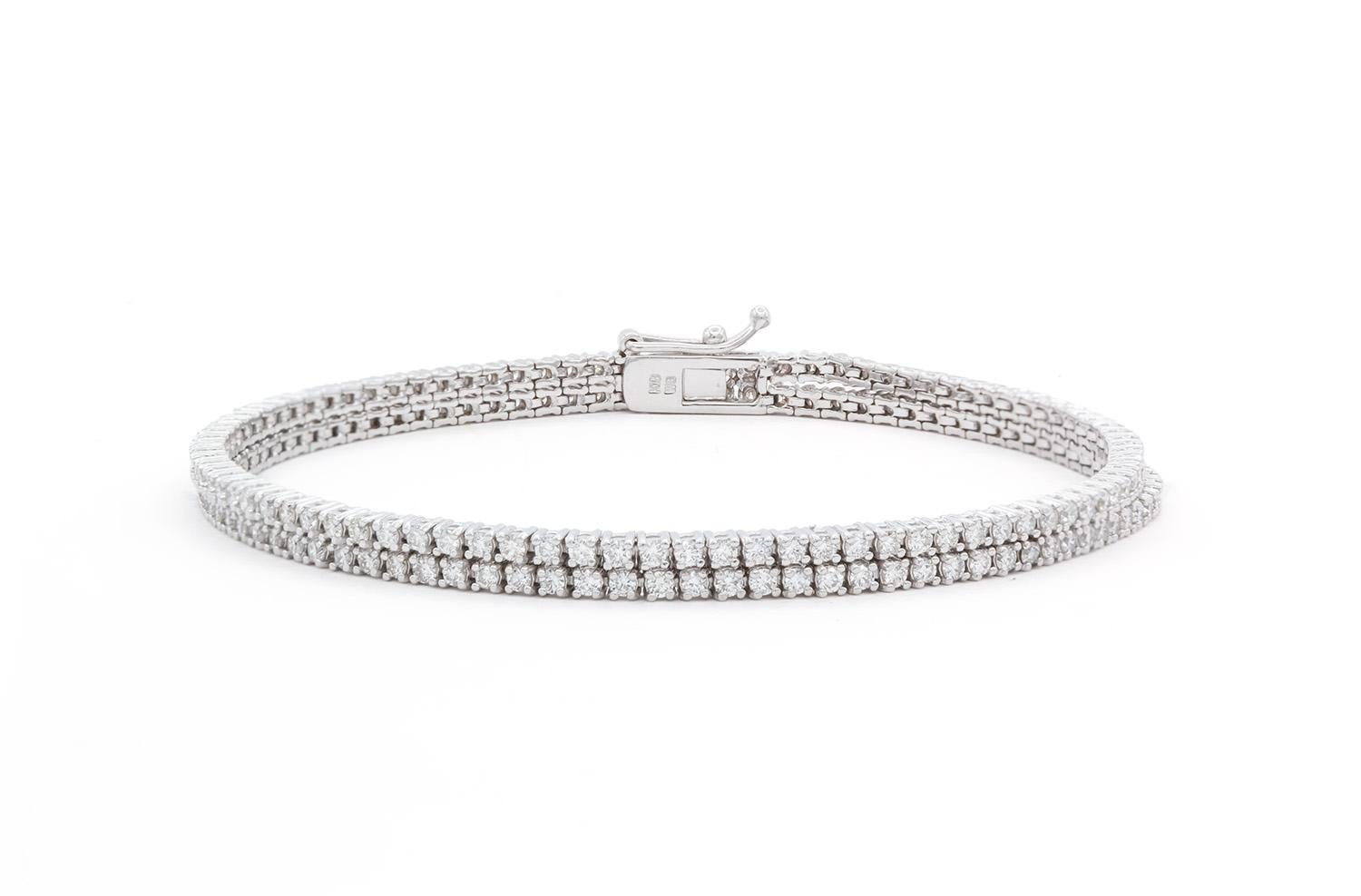 We are present this beautiful 18k White Gold & Diamond Double Strand Tennis Bracelet. It features two strands of diamonds with an estimated 2.50ctw G-H/VS-SI round brilliant cut diamonds set in this 18k white gold. The bracelet measures 7″ long and