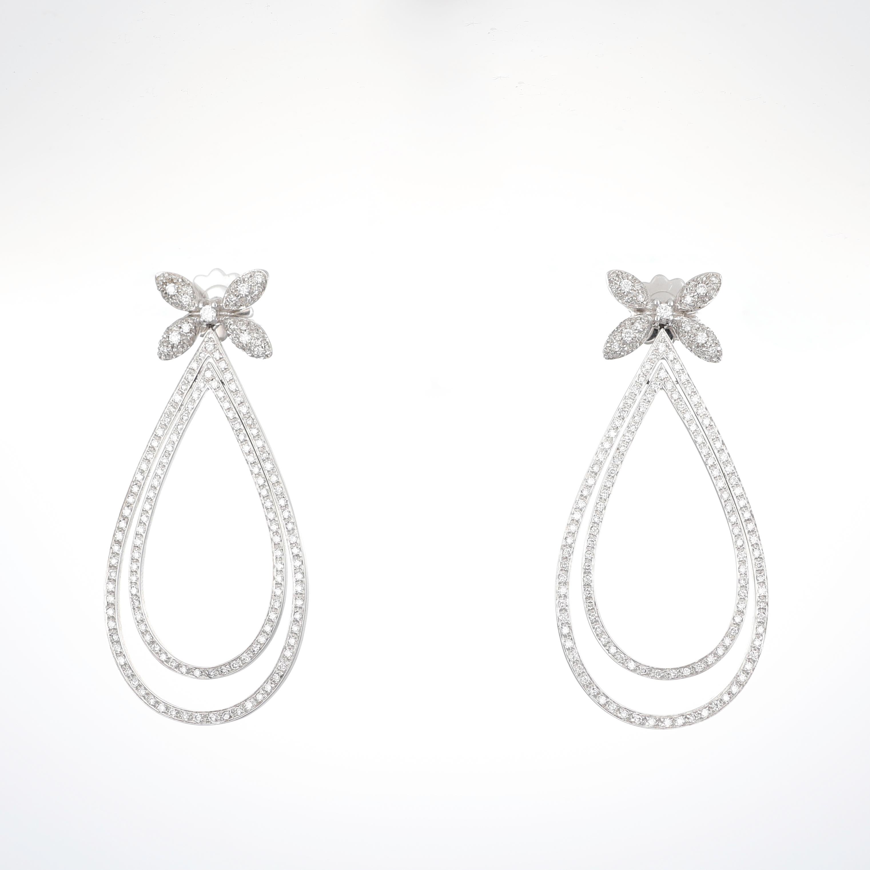A delicate yet striking expression of elegance, these 18K white gold drop earrings feature an intricate openwork design adorned with brilliant-cut diamonds totaling 2.95 carats. The floral-inspired stud leads into double pear-shaped frames,