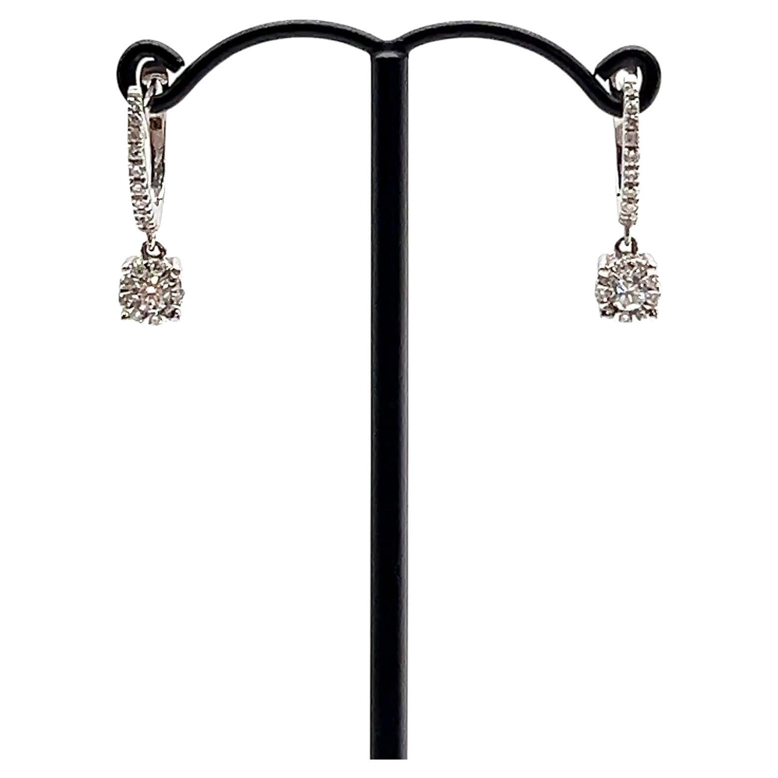 Questi eleganti orecchini a goccia con diamante sono realizzati in oro bianco 18 carati e combinano un design senza tempo con una brillantezza di lusso. Ogni orecchino presenta un diamante centrale con taglio a brillante delicatamente sospeso da un