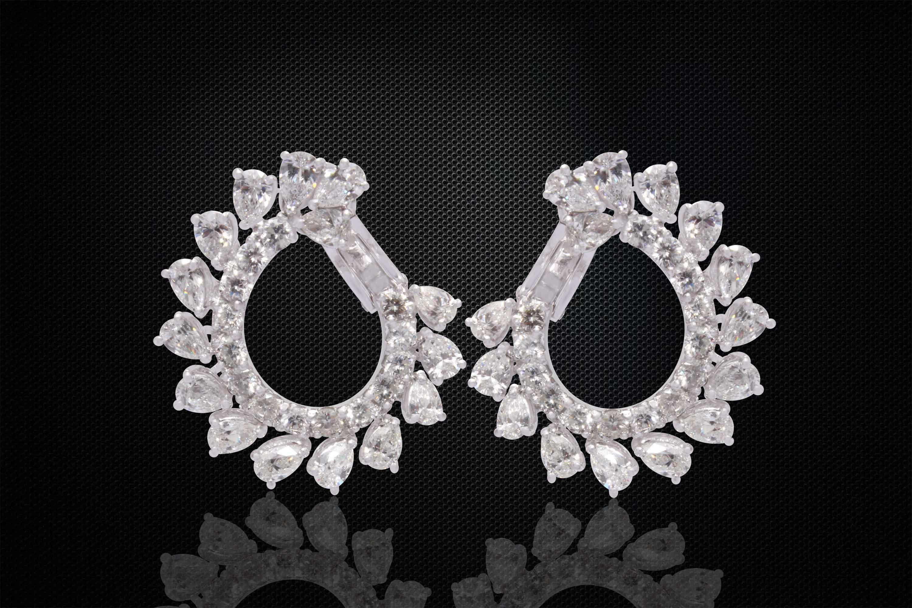 Extremely fine pair of white gold diamond earrings, fine set with bright, white and sparkly round & pear cut diamonds.
These handcrafted earrings display the finest workmanship in setting and finish, having just the right curvature to create an