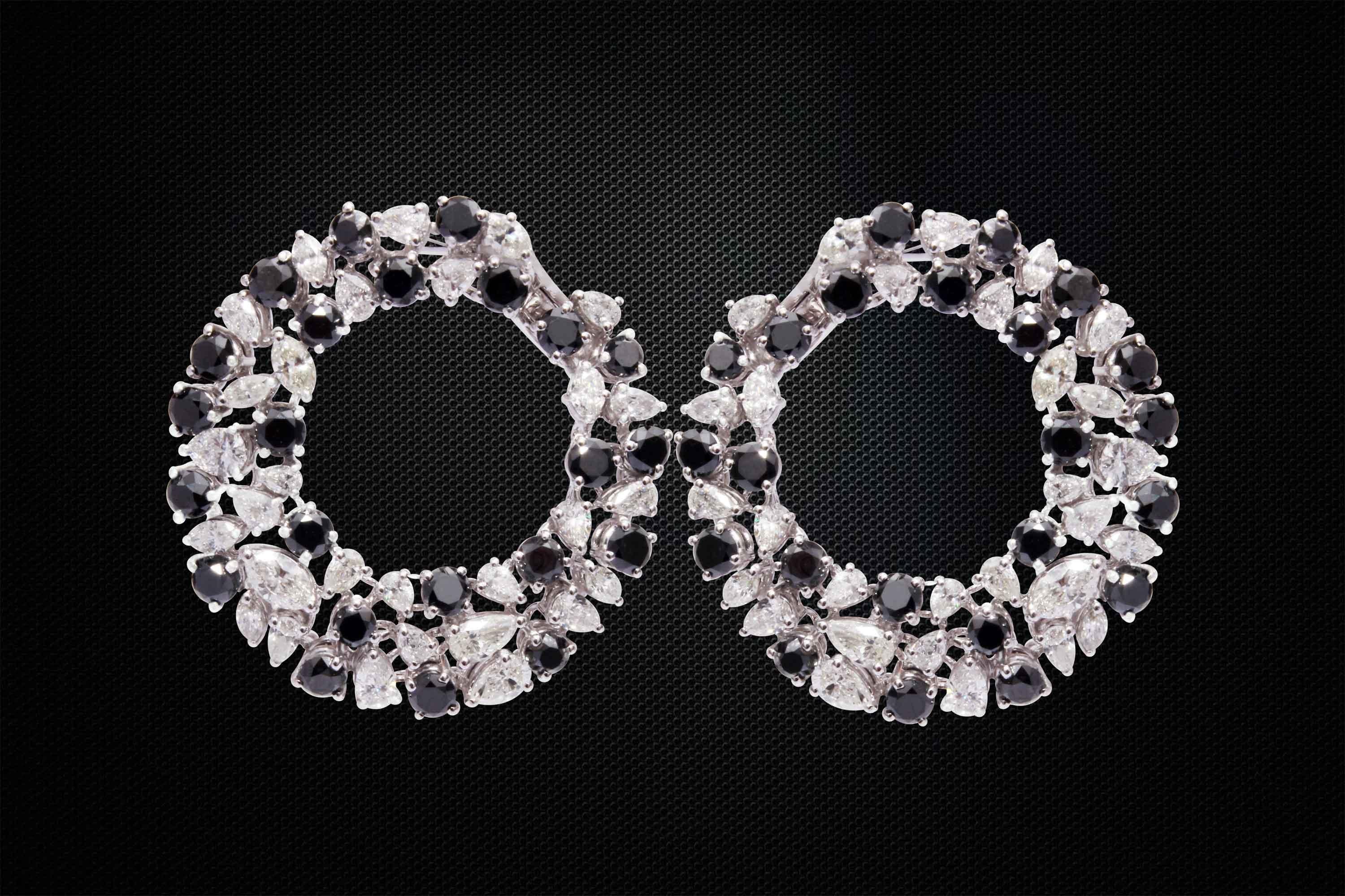 Stylish unique pair of Earrings are embellished with 46 pieces of round cut black diamonds weighing approximately 8.13 carats, 15 pieces of marquise white diamonds weighing approximately 1.39 carats and 43 pieces of pears cut white diamonds weighing