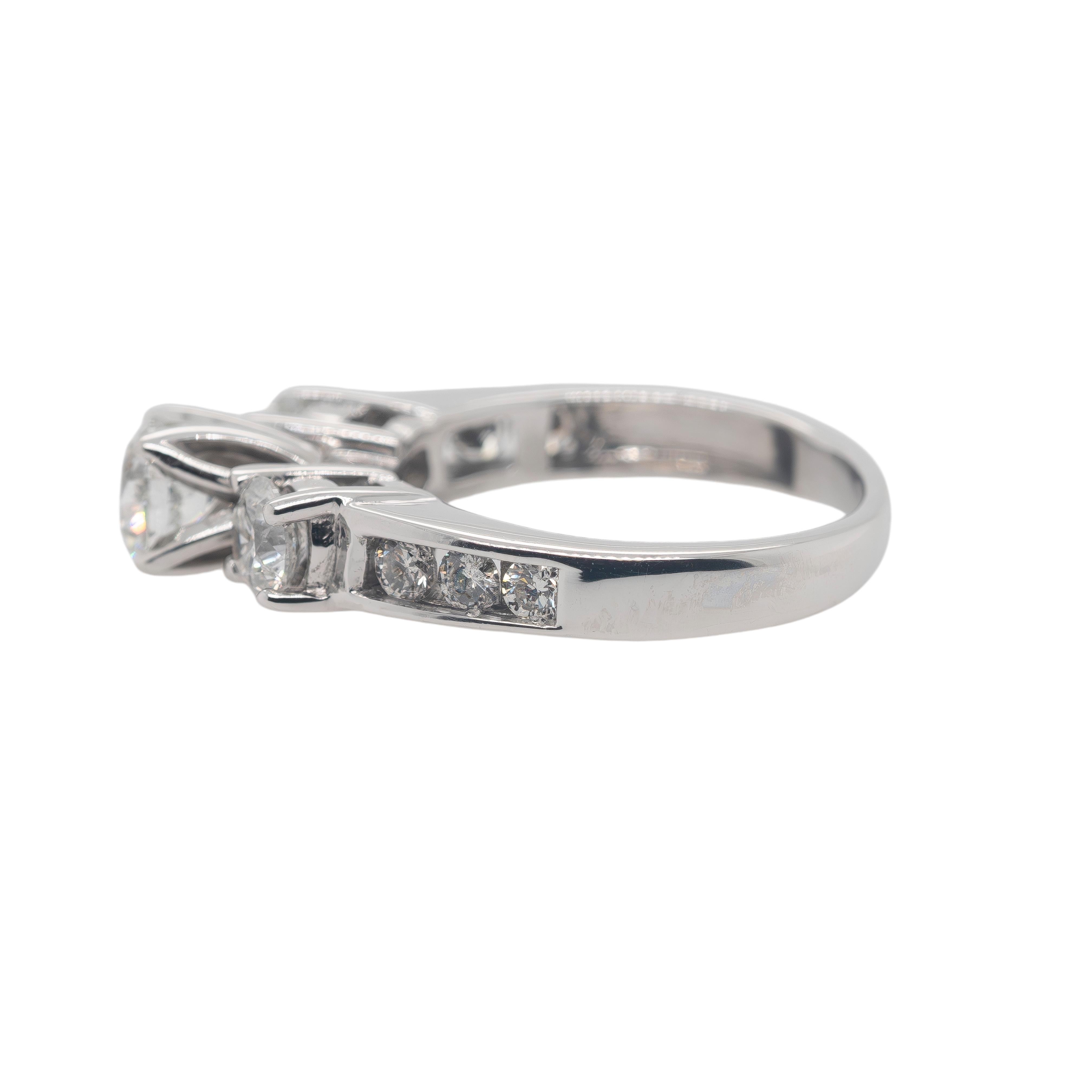 Cette exquise parure de bague de fiançailles en or blanc 18 carats est un symbole d'élégance intemporelle, avec un poids total d'environ 1,28 carats de diamants ronds naturels de taille brillant. Chaque diamant est serti de manière experte afin de