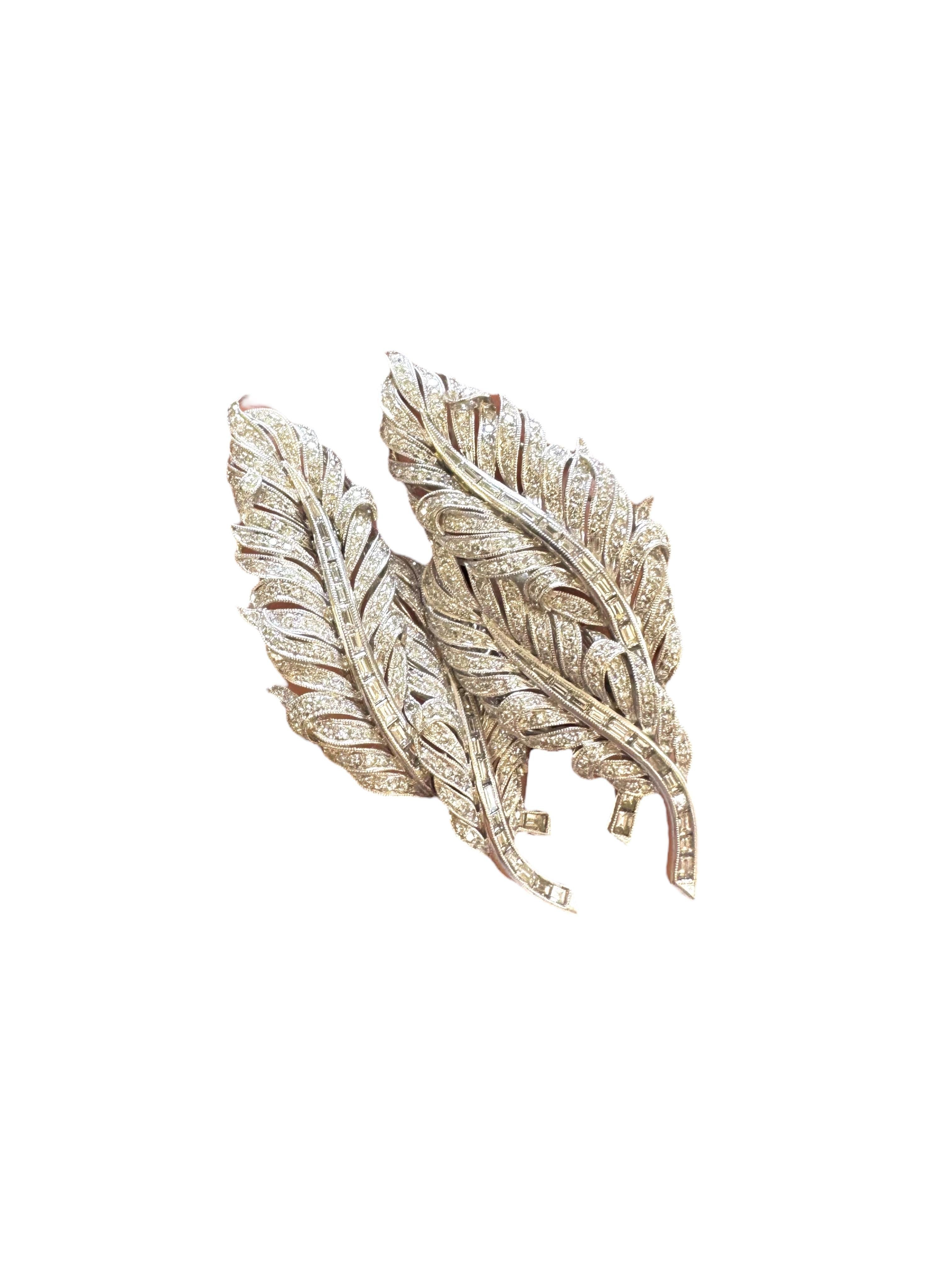 A dazzling pair of 18 karat white gold and diamond feather pins, famously worn by Yvonne Orji to the 2025 Met Gala. These exquisite pins feature an impressive total of 445 brilliant round diamonds, weighing approximately 2.90 carats, alongside 54