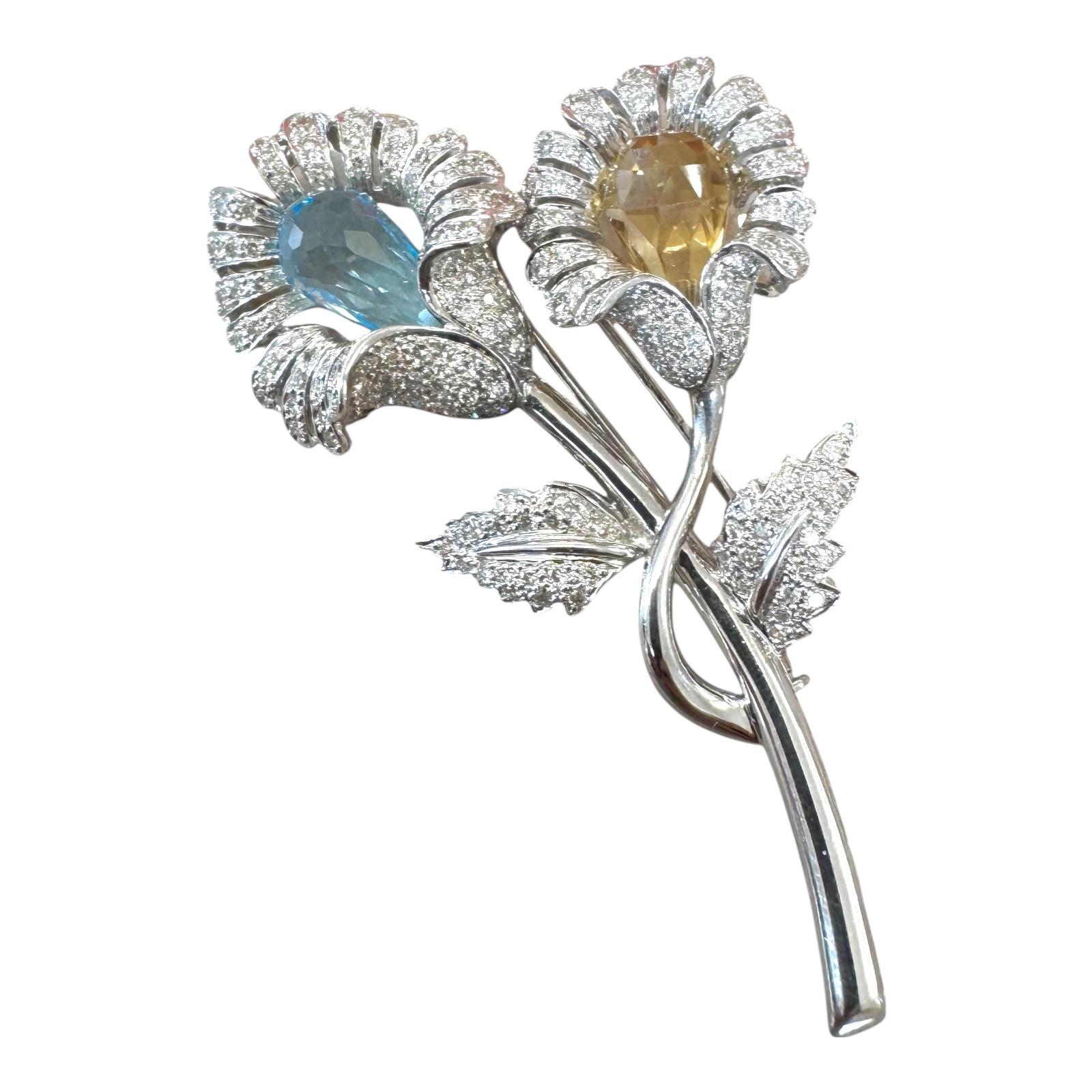 Broche florale vintage éblouissante en or blanc 18 carats, ornée de deux pierres précieuses taille briolette : une aigue-marine froide et une citrine dorée chaleureuse. Chaque fleur est rehaussée de diamants pavés le long des pétales et des