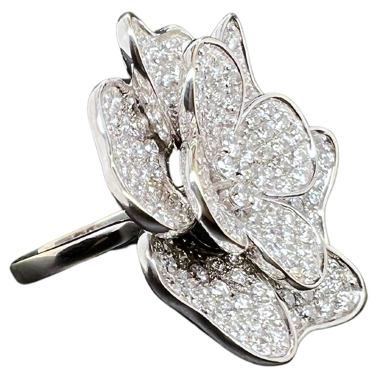 This whimsical ring is absolutely gorgeous and perfect to wear for luncheons and events! The 18k white gold setting houses the floral pattern encrusted with round brilliant diamonds on the petals. The large top floral petals makes its stand out
