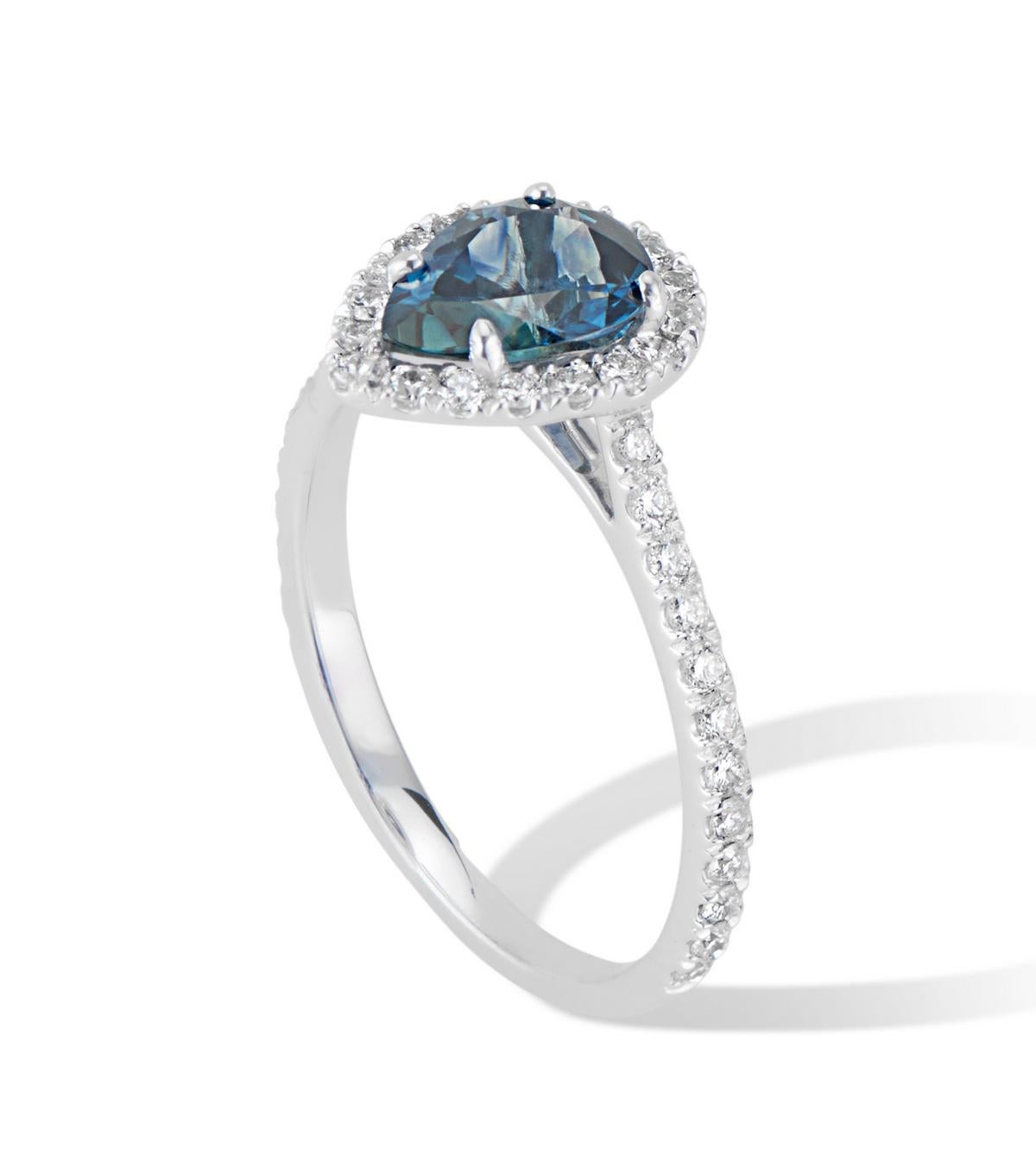 Ein atemberaubender birnenförmiger Montana-Saphir von 1,31 Karat, eingefasst in einen funkelnden Halo aus weißen Diamanten in VS-Qualität, ergibt einen exquisiten modernen klassischen Ring.
Dieser wunderschöne Ring ist in eine hochwertige