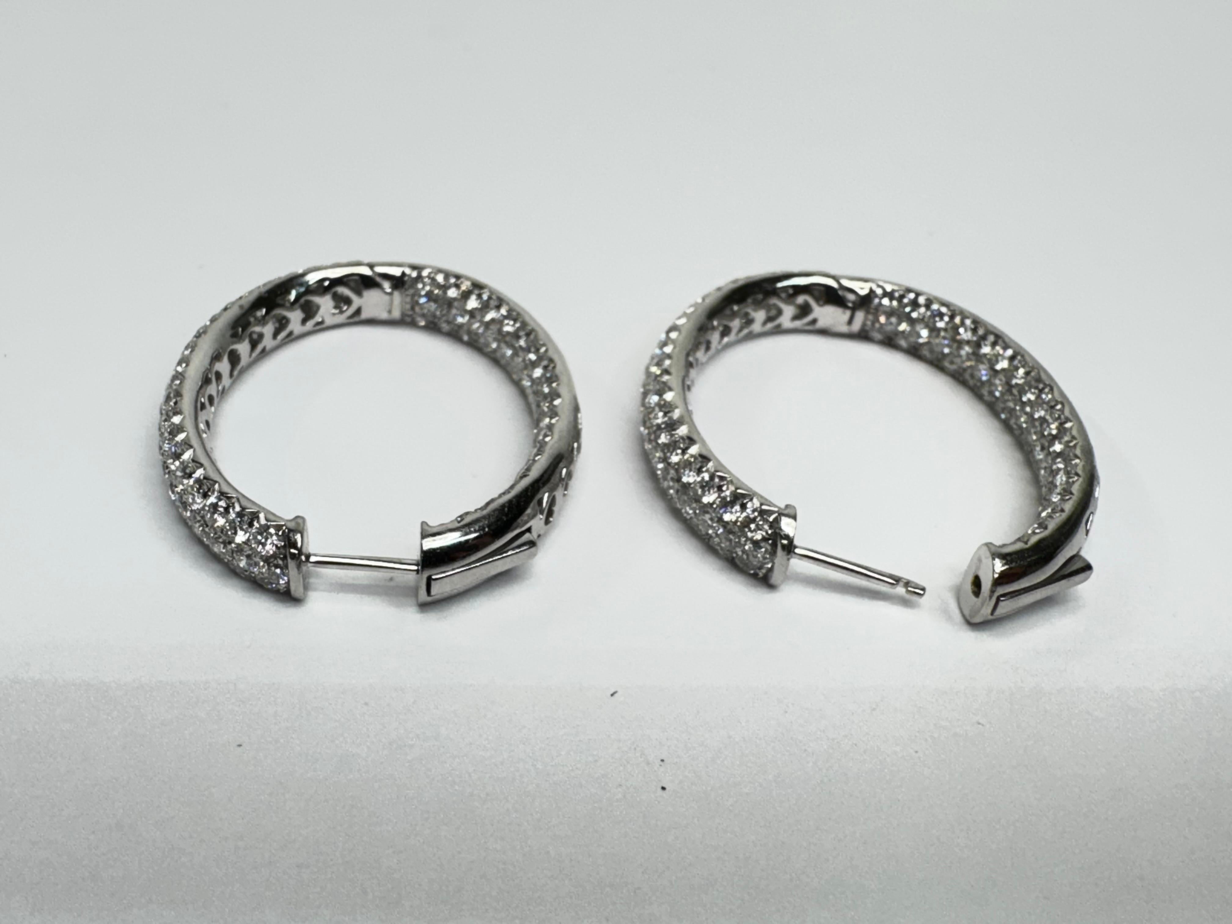 These exquisite 18k white gold diamond hoop earrings are adorned with 222 round brilliant diamonds, totaling 5.47 carats. The diamonds are meticulously pave-set in a heart-shaped in-and-out design, ensuring maximum sparkle from every angle.