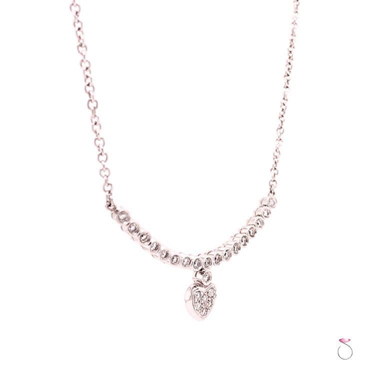 Beautiful diamond neckalce with drop heart motif in 18k white gold. This gorgeous necklace features 17 round diamonds bezel set at the center of a chain with a heart shape drop pendant pave set with 6 round diamonds. The diamond section is hinged