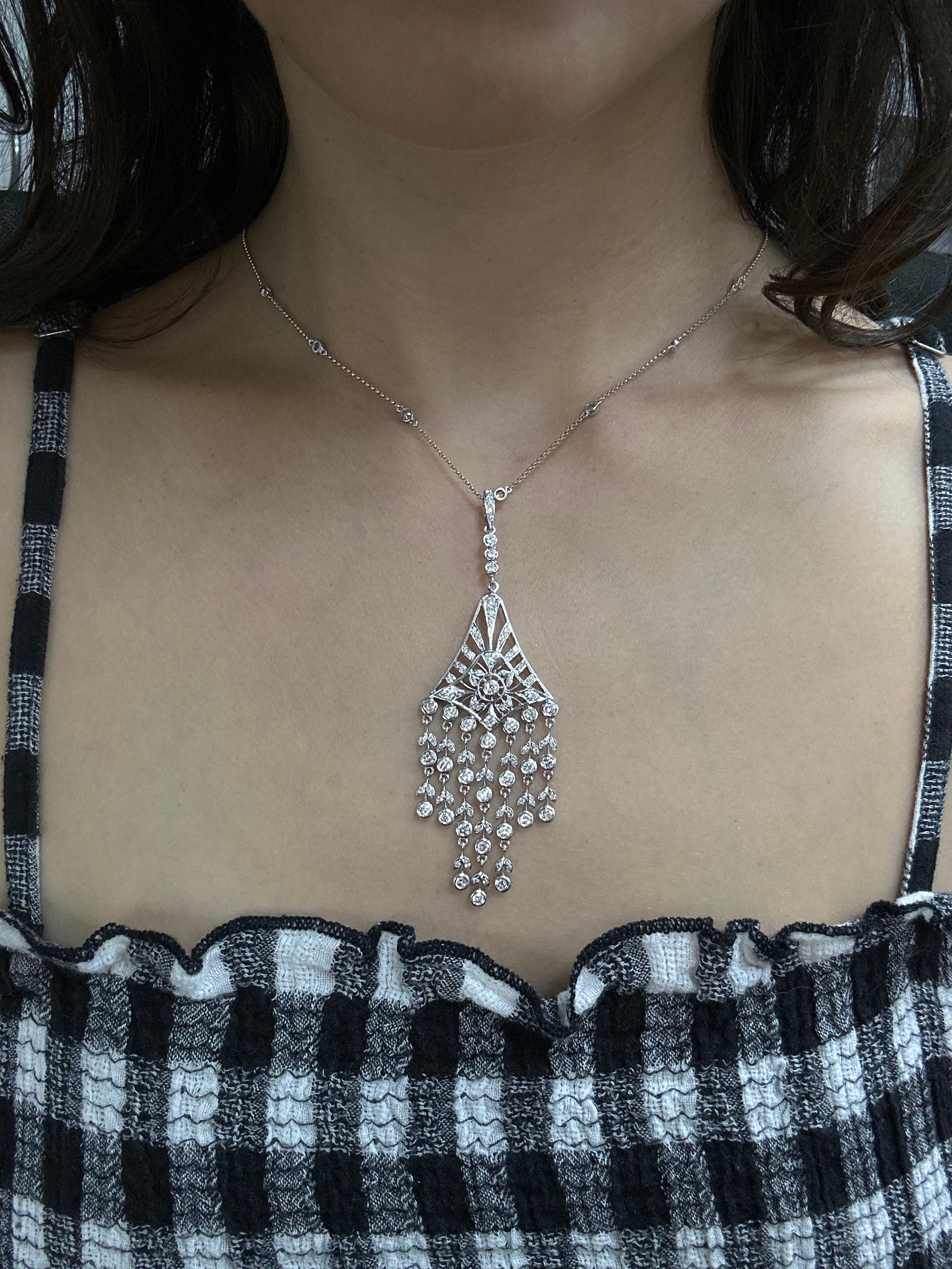 This necklace features an intricate, chandelier-style pendant in 18K white gold, accented throughout with diamonds. The 3.4-inch-long pendant features delicate strands with bezel-set diamonds that sway gracefully with movement, complemented by