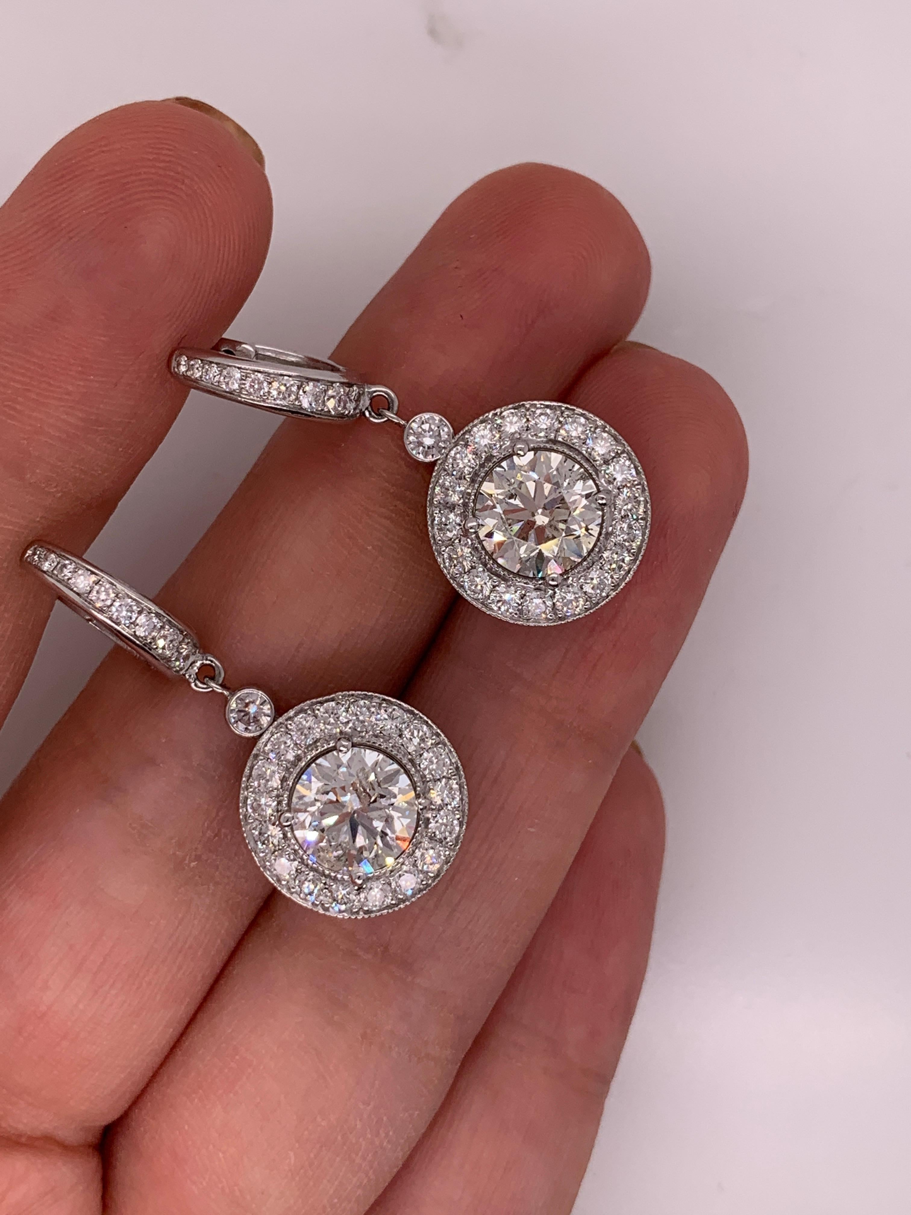 18k white gold features round cut diamond surrounded by round brilliant cut diamonds set in a bezel. 

Two center diamonds are 4.75 Carats, surrounded by 1.90 carats of diamonds. 

Diamond encrusted post

Lever back closure

Length of drop: 1