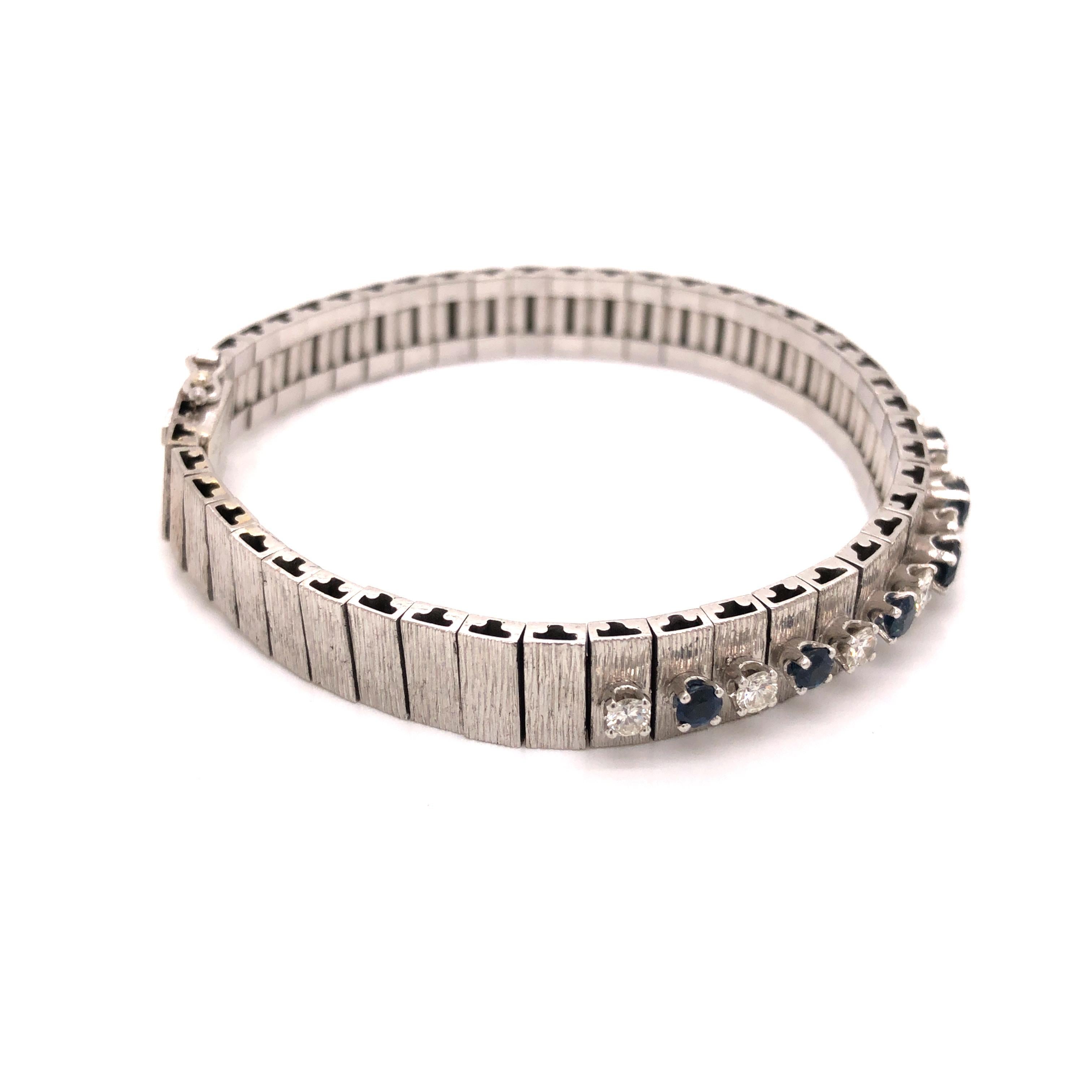18K white gold textured bracelet featuring a graduated row composed of alternating round sapphires and round diamonds weighing a total of approximately 1 carat, G-H color, VS clarity.

Stone: Sapphire, Diamond

Metal: 18K White Gold

Size: 7