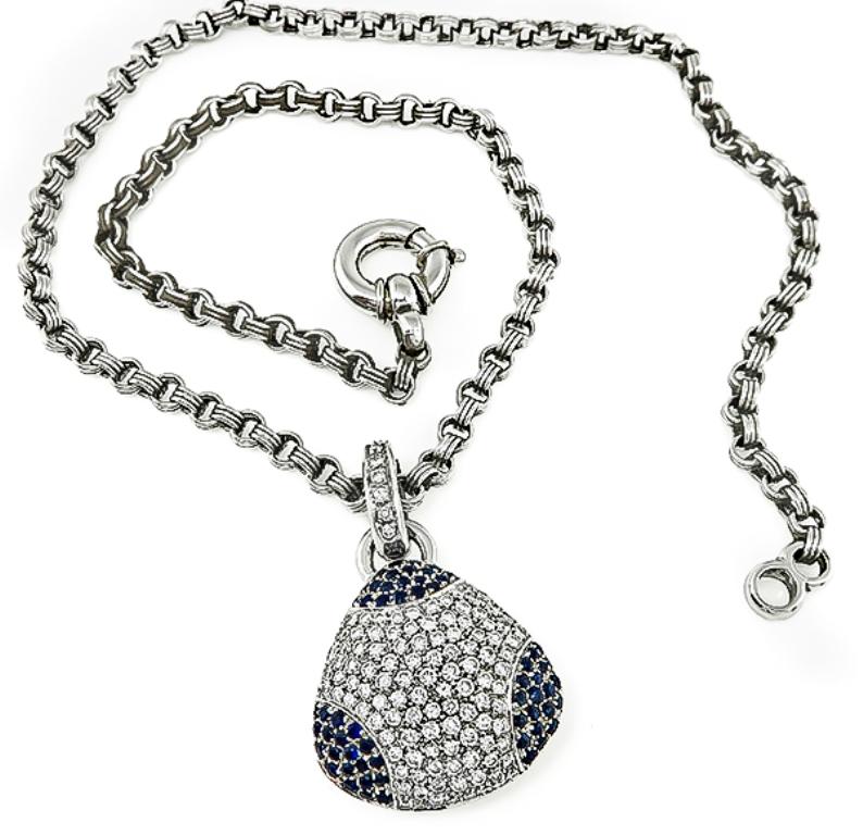 This fabulous 18k white gold pendant is set with sparkling round cut diamonds that weigh approximately 3.00ct. graded G-H color with VS clarity. The diamonds are accentuated by lovely round cut sapphires that weigh approximately 1.50ct. The pendant