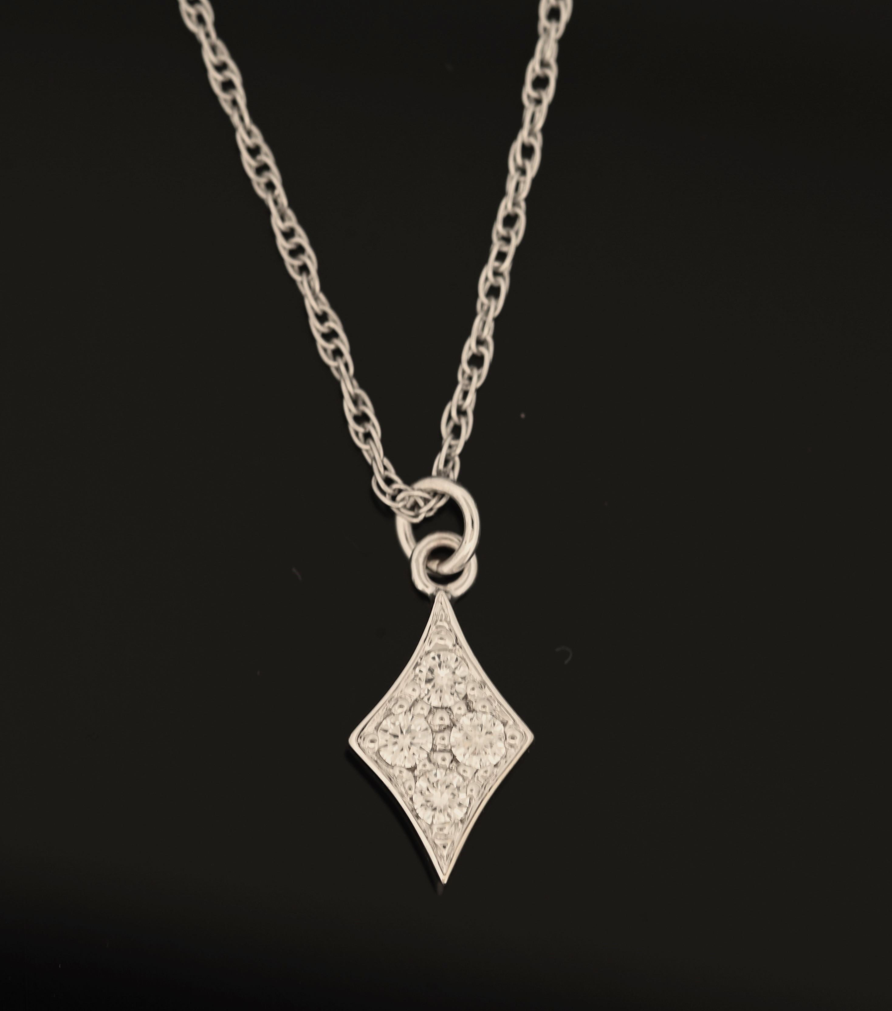 Illuminez votre style avec le charme exquis de ce collier en or blanc, doté d'un pendentif en forme de diamant saisissant. Fabriqué en or blanc lustré, ce collier de 18 pouces offre un look sophistiqué et contemporain qui rehausse sans effort
