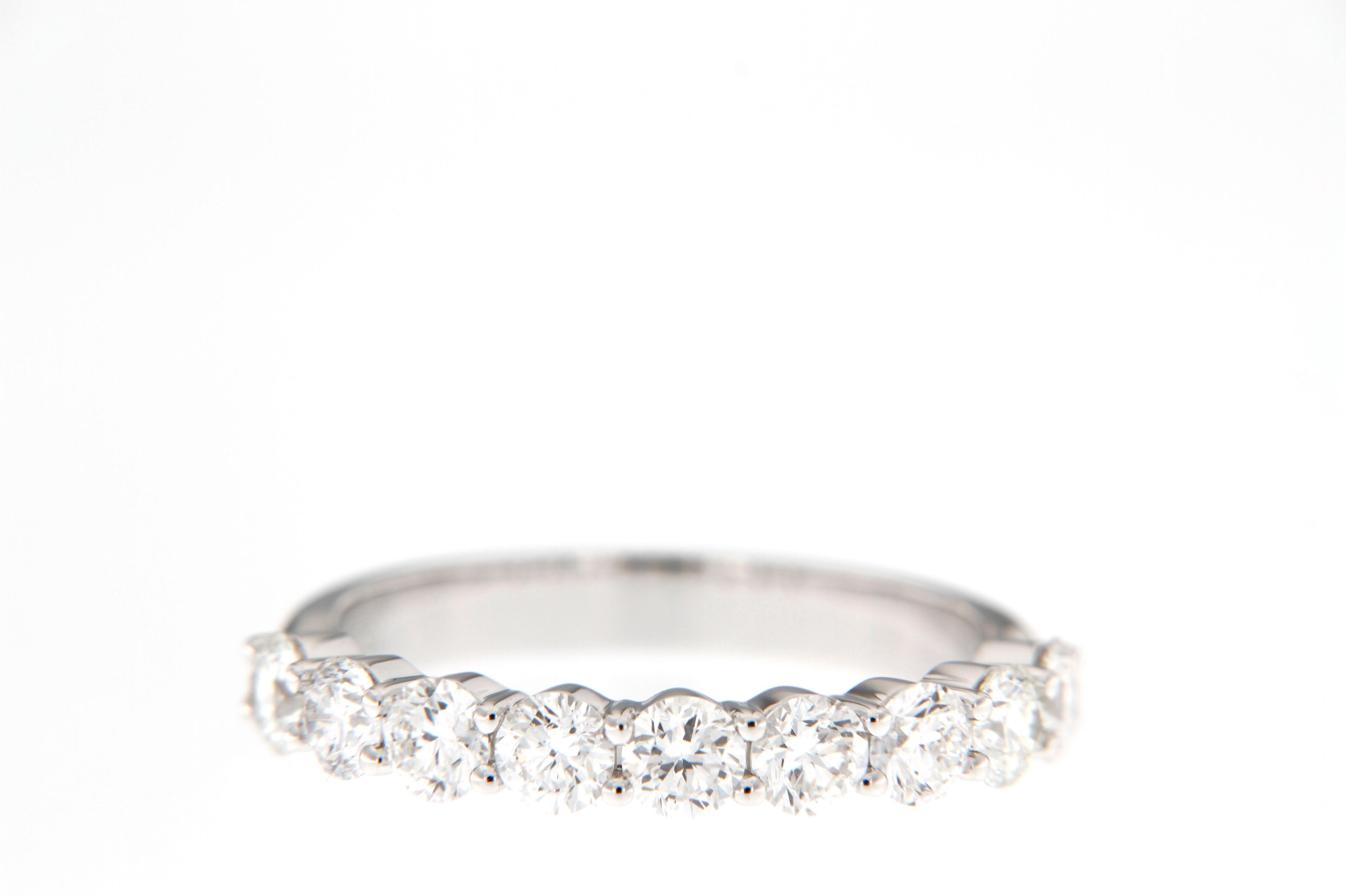 Réalisée en or blanc 18 carats lumineux, cette alliance en diamant affiche une sophistication intemporelle avec une rangée d'éblouissants diamants ronds de taille brillant. 

Sertis dans une monture à griffes partagée, les diamants créent un flux