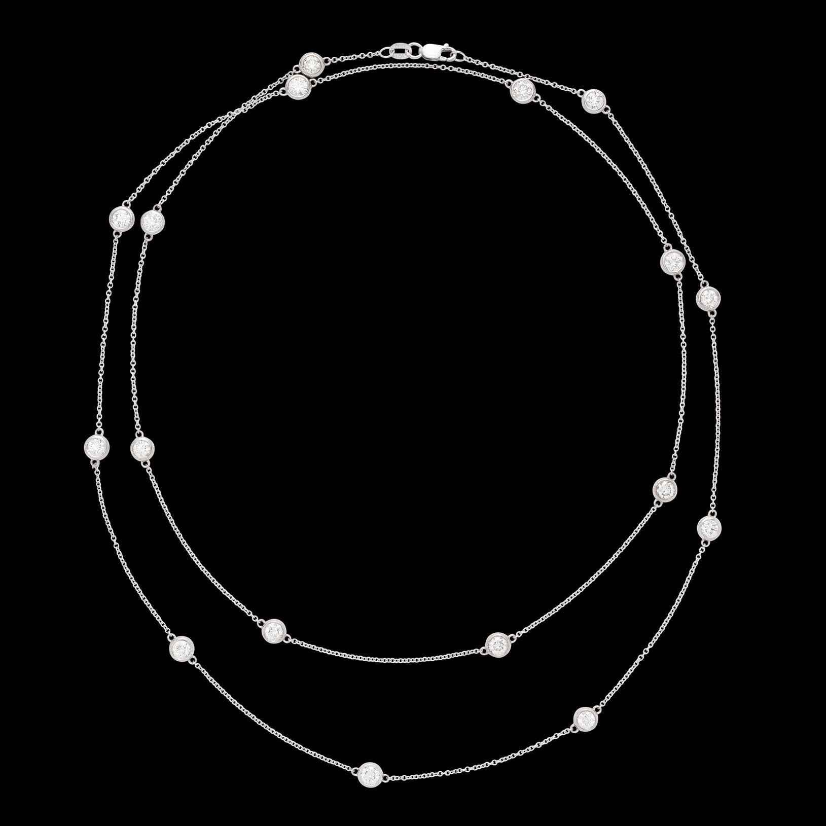 Versatile and forever fashionable! This 18 karat white gold station necklace measures 34 inches long, allowing it to be worn full length, or wrapped and doubled for a completely different look. The chic diamonds by the yard style necklace features