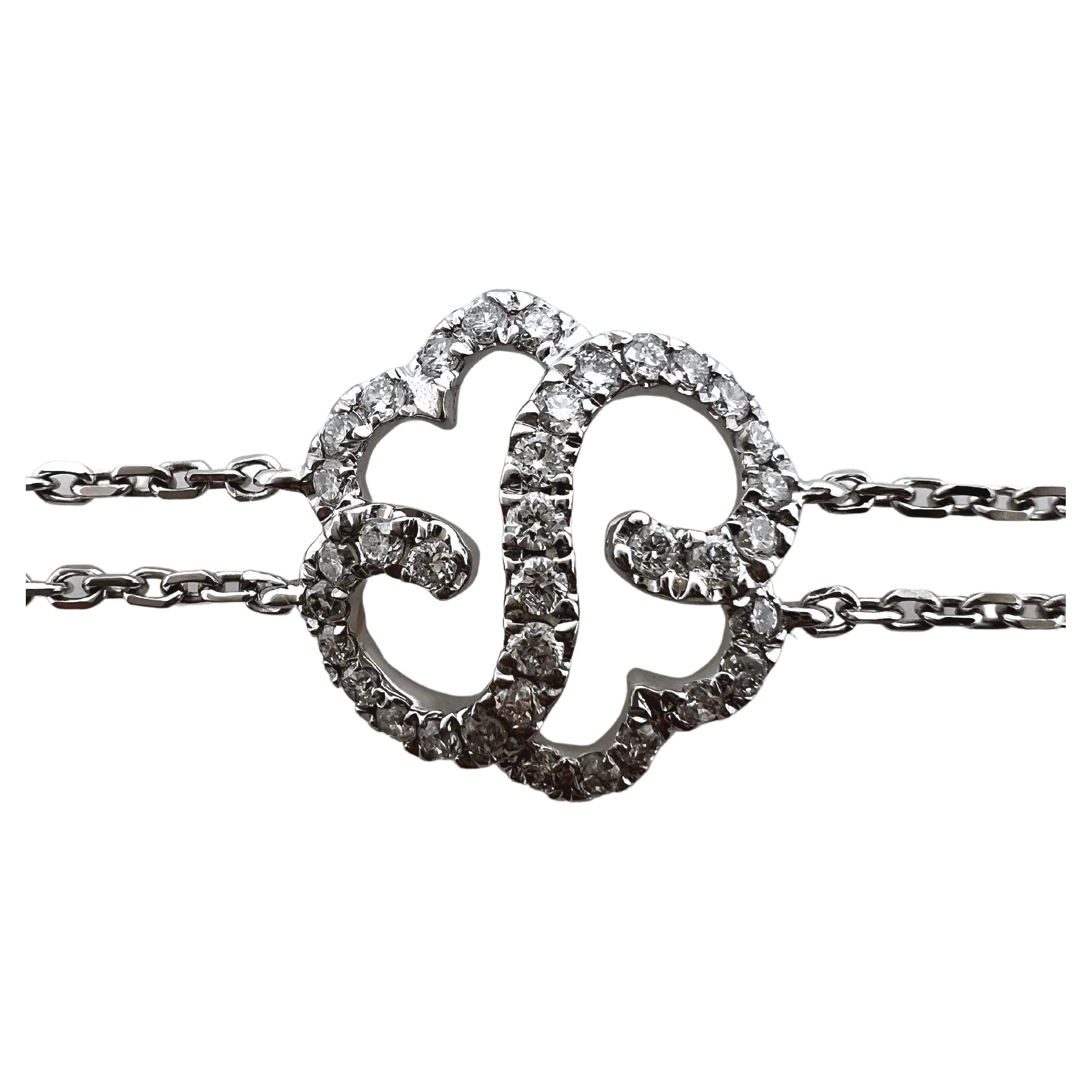 This elegant and dainty diamond bracelet is made for the daily wear.  It has a double strand of 18k white gold chains that link up the center diamond floral design.  The round diamonds comprise the pattern and has adjustable jump rings so that it