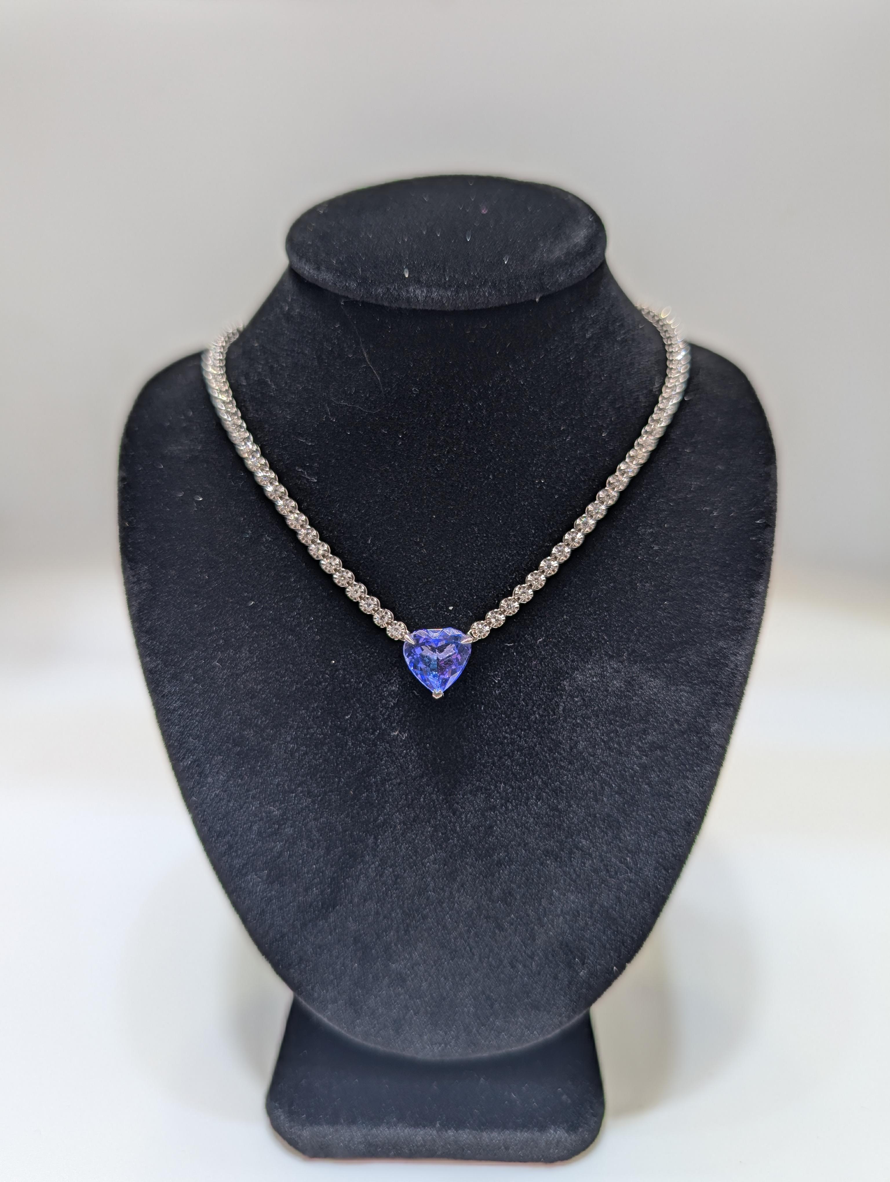 This stunning 18-karat white gold tennis necklace is a true masterpiece, featuring a seamless line of dazzling diamonds totaling 2.06 carats. At the center, a breathtaking tanzanite heart-shaped pendant weighing 3.54 carats adds a vibrant pop of