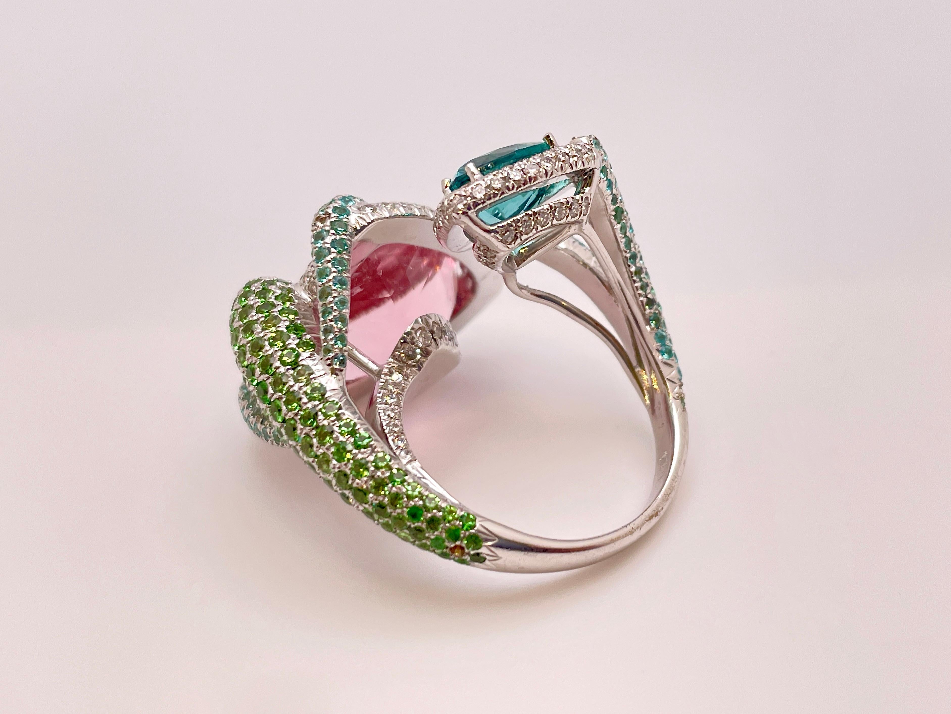 An original 18K white gold Avakian signed diamond tsavorite and tourmaline cocktail snake ring. Centered with one approximately 10.00 CT triangular brilliant cut natural pink tourmaline measuring approximately 14.50 x 14.50 x 8.50 MM, and one