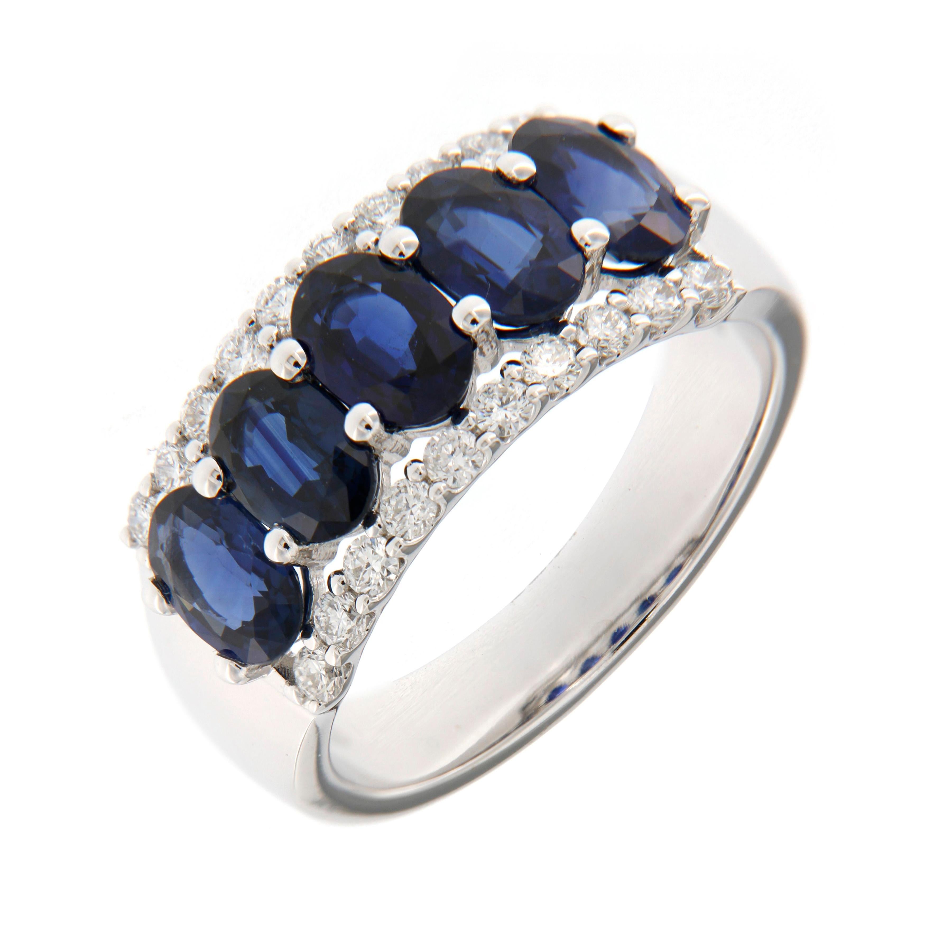 Questo elegante anello in oro bianco 18 carati combina un fascino senza tempo con un sorprendente contrasto di colori. Al centro si trova uno zaffiro blu, famoso per la sua profondità e brillantezza, che simboleggia saggezza e devozione. 
Lo zaffiro