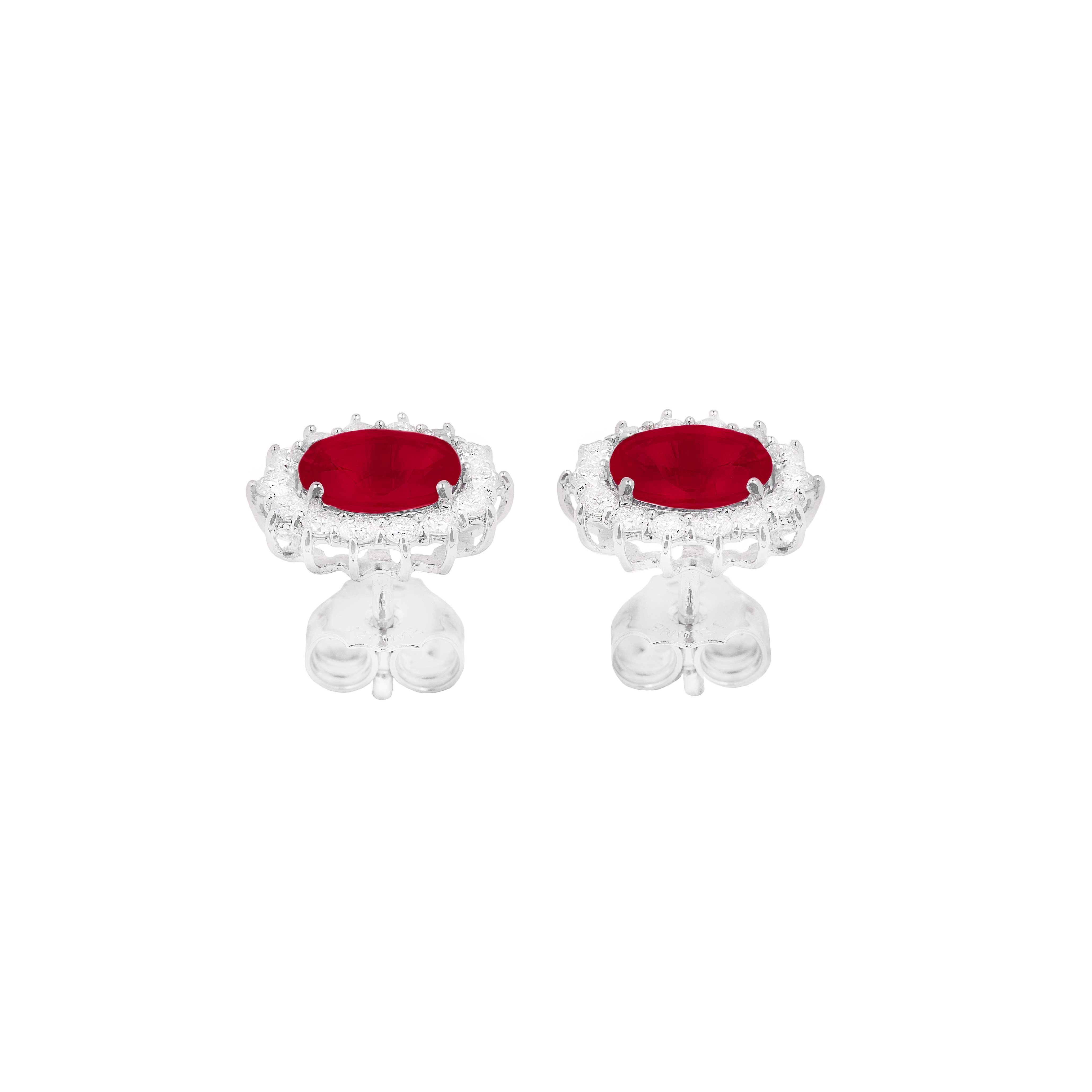 These bright 18K white gold earrings are made in Italy by LeLune.
They feature a stud closure and each earrings consist of one oval cut ruby red in the centre surrounded by a row of smaller brilliant cut white diamonds.

Rubies 1.16ct 
Diamonds