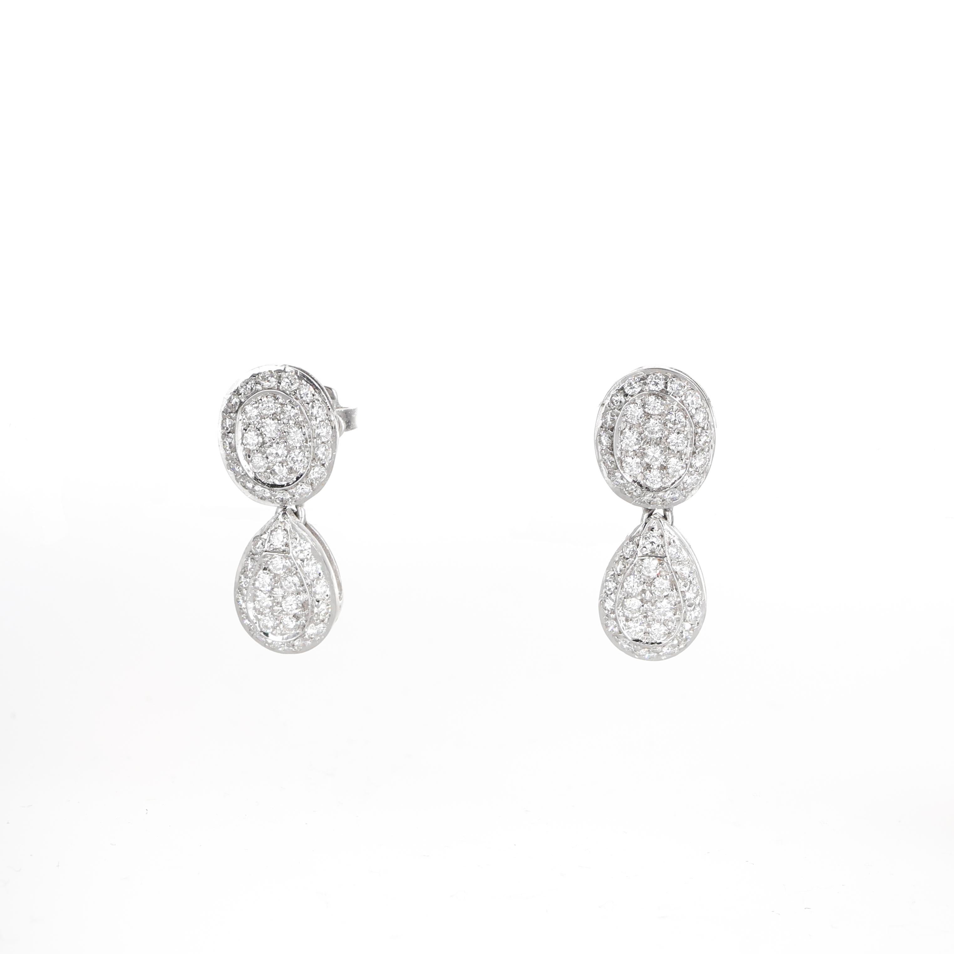 A refined pair of drop earrings crafted in 18K white gold, featuring an oval-shaped top and a teardrop-shaped bottom, both adorned with a pavé of brilliant-cut diamonds. With a total diamond weight of 0.95 carats, these earrings offer a