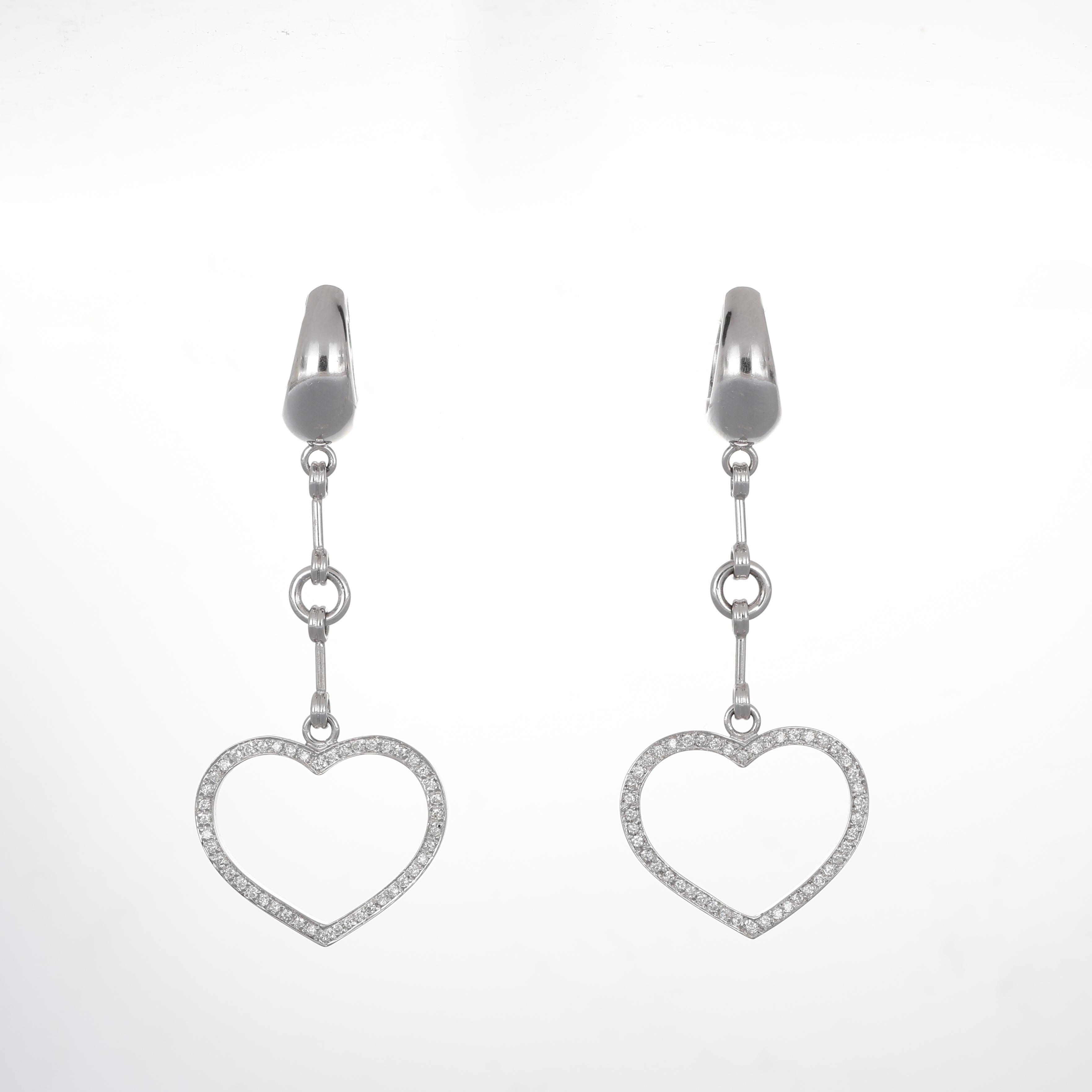 An elegant pair of drop earrings crafted in 18K white gold, featuring a delicate heart-shaped charm adorned with a pavé of brilliant-cut diamonds. With a total diamond weight of 0.68 carats, these earrings offer a timeless and romantic design. The