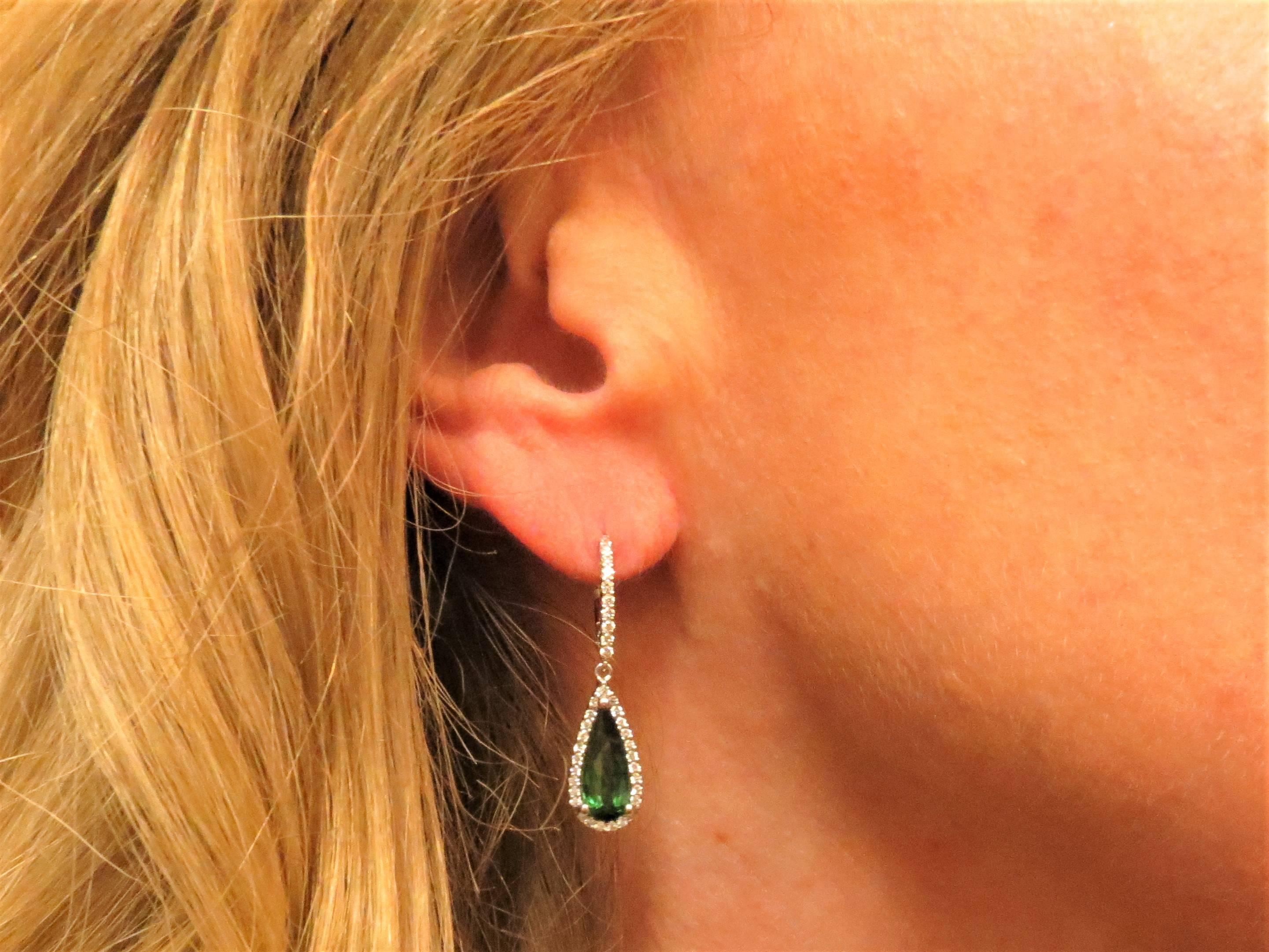 18K white gold drop earrings set with two pear shape green tourmalines surrounded by 76 full cut round diamonds weighing .50cts, G-H color, VS clarity