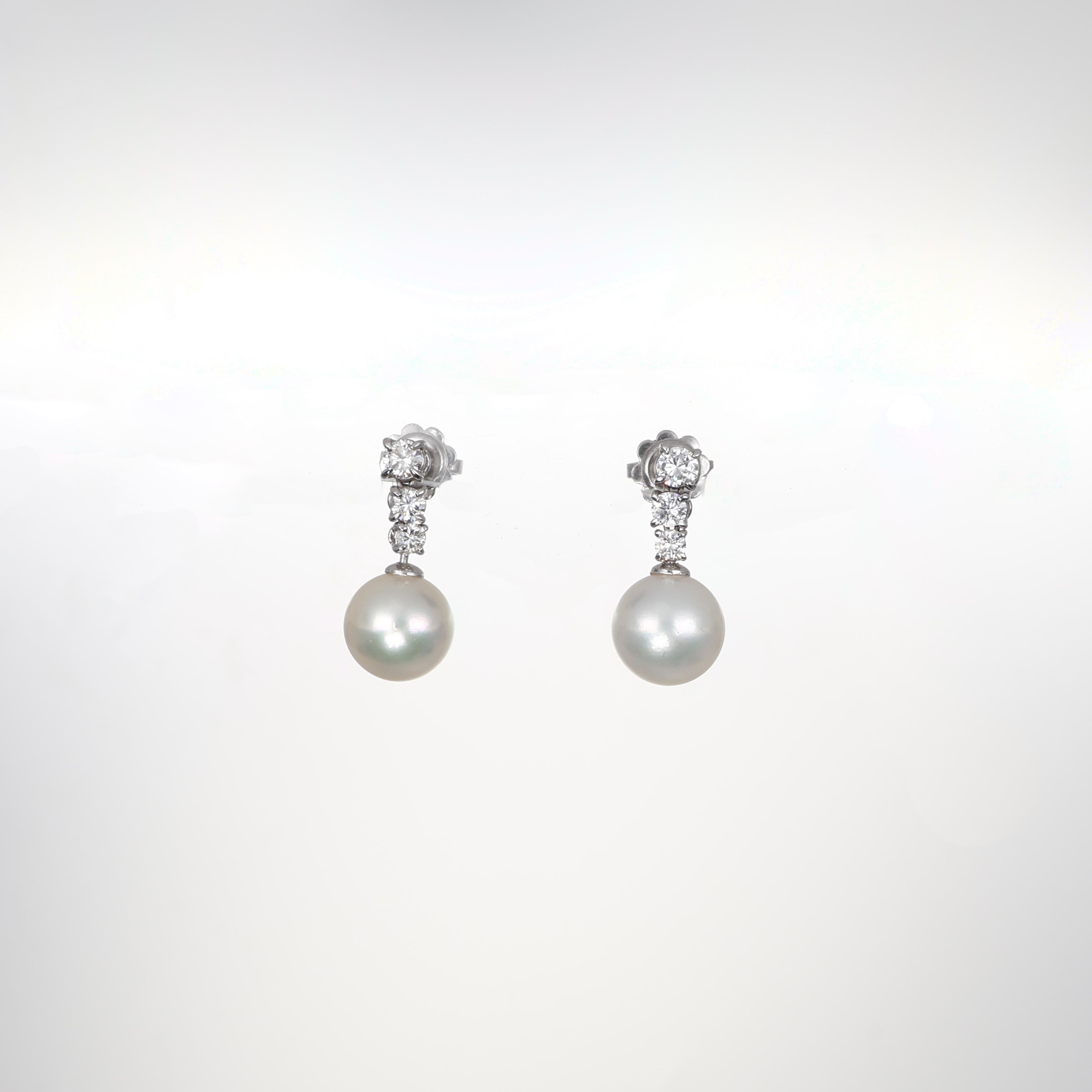 Refined and elegant, these drop earrings in 18K white gold showcase luminous pearls suspended from a delicate cascade of three brilliant-cut diamonds. The design enhances the natural radiance of the pearls and the brilliance of the diamonds, making