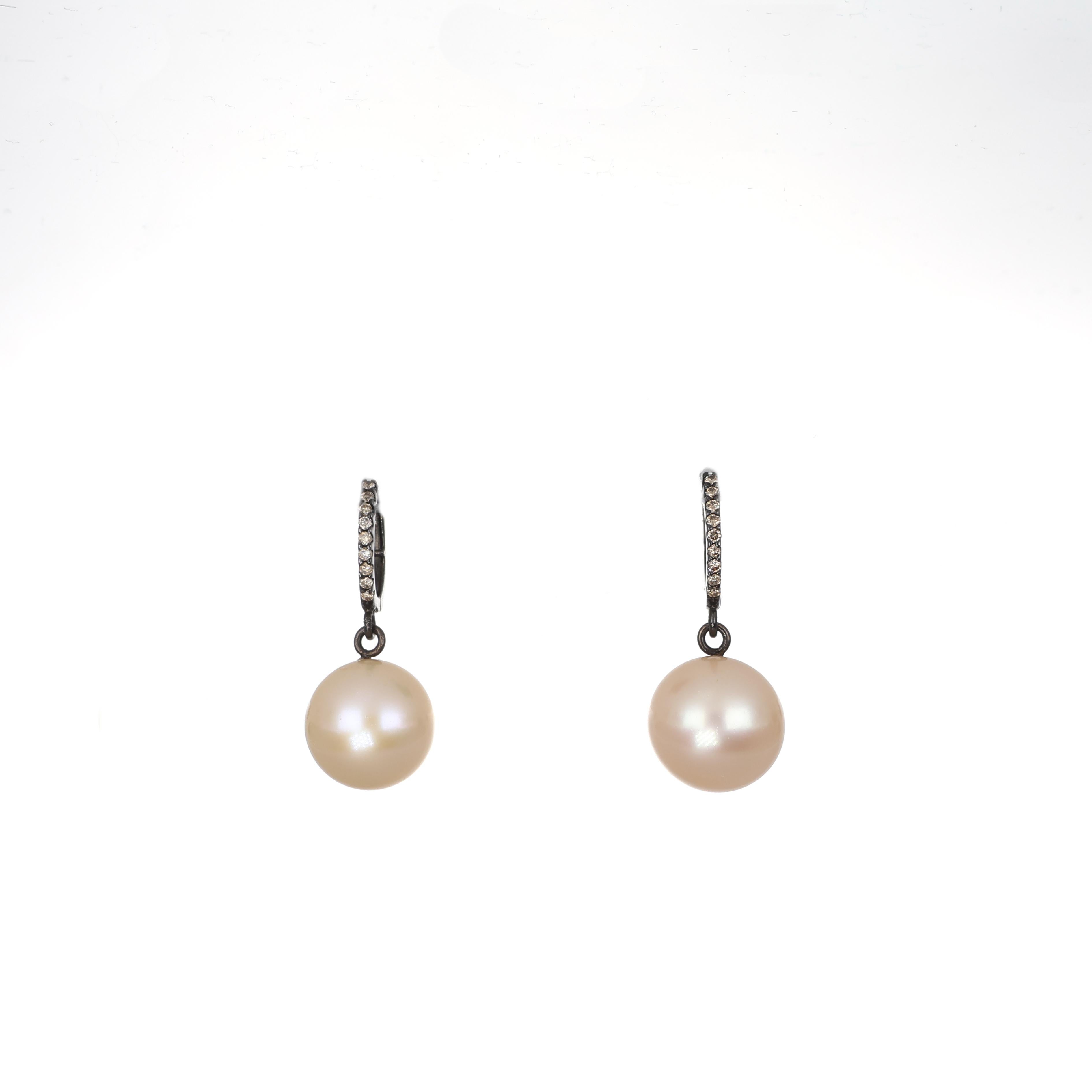 Eleganti orecchini a goccia realizzati in oro bianco 18 carati, con una luminosa perla naturale sospesa da un cerchio tempestato di diamanti. La delicata incastonatura esalta la brillantezza dei diamanti e completa la morbida lucentezza delle perle.
