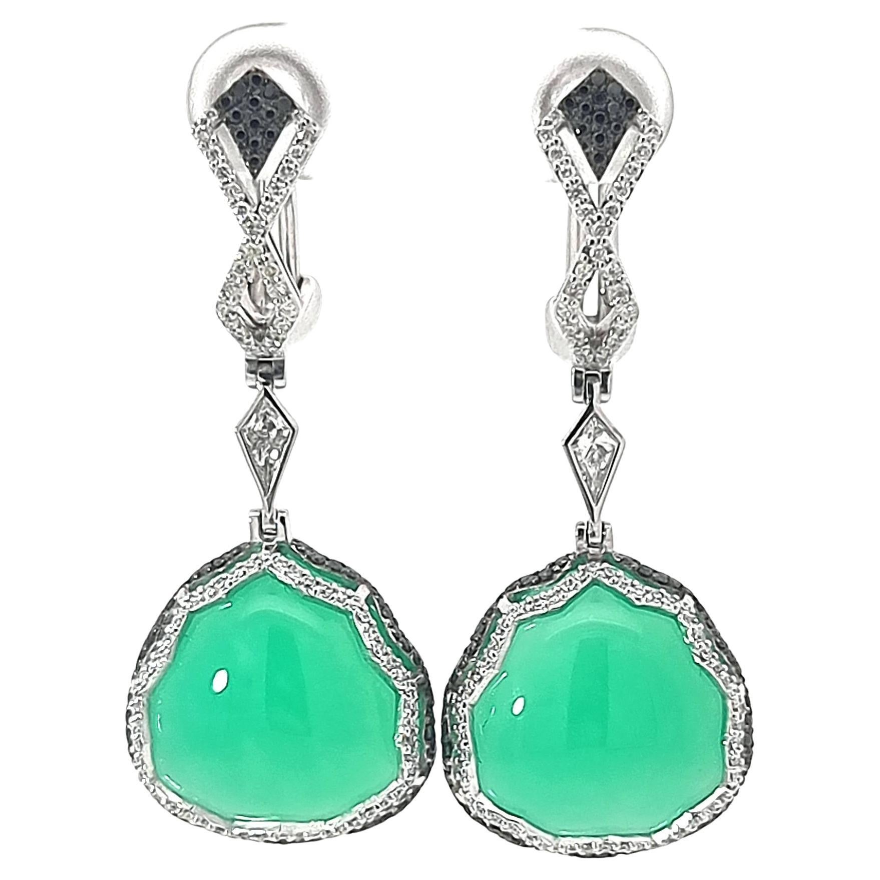 Gli orecchini Souvenir D'Azure della Collection'S Lace di VOTIVE incarnano un portamento raffinato e un'allure senza tempo, evocando il fascino languido delle coste mediterranee. Il cuore è un morbido crisoprasio trilaterale che evoca le acque