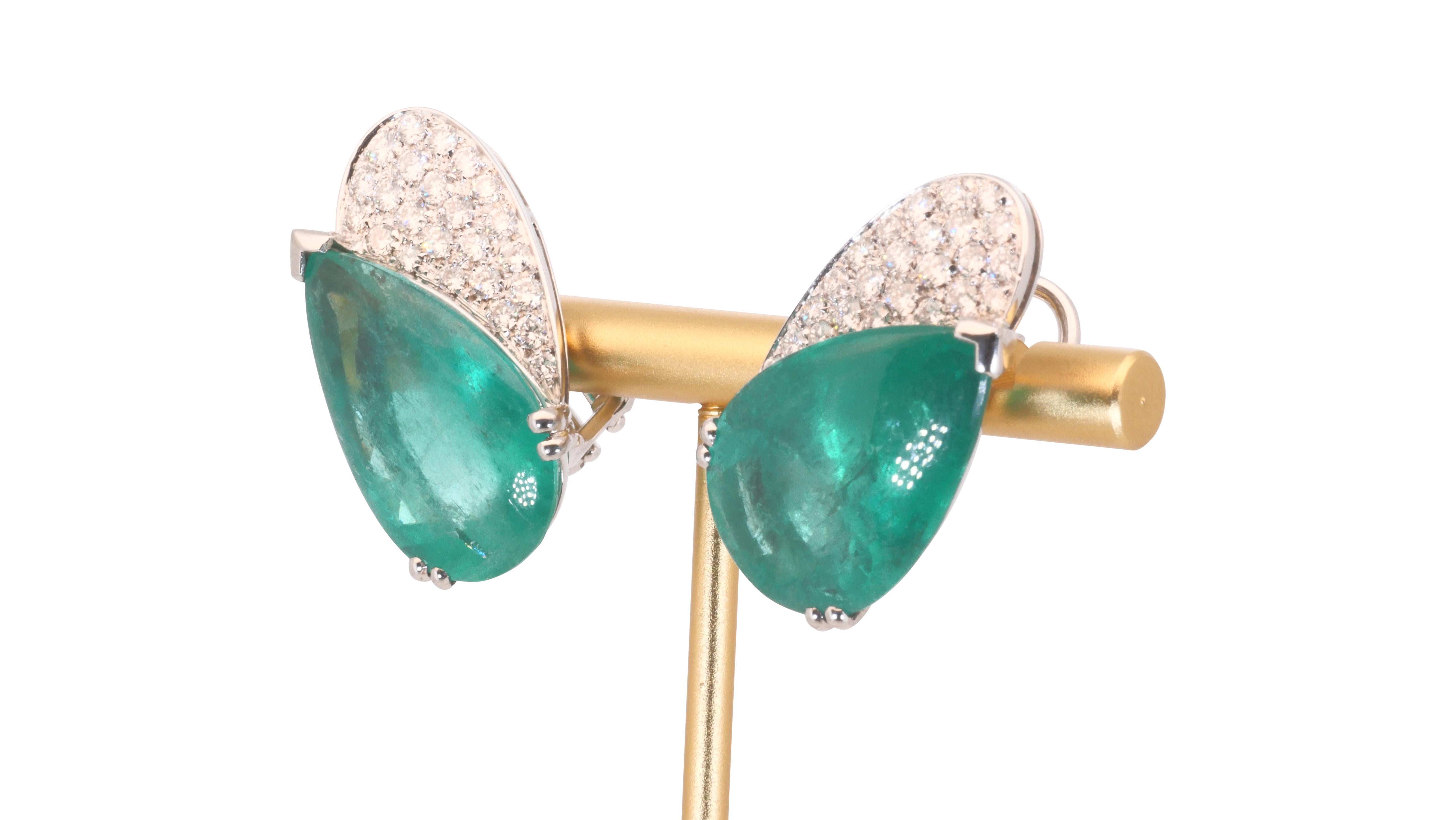 An elegant pair of earrings with a dazzling 6 carat  natural emerald. It has 1.59 carat of side diamonds which add more to its elegance. The jewelry is made of 18k white gold with a high quality polish. It comes with GRS Certificate and a fancy