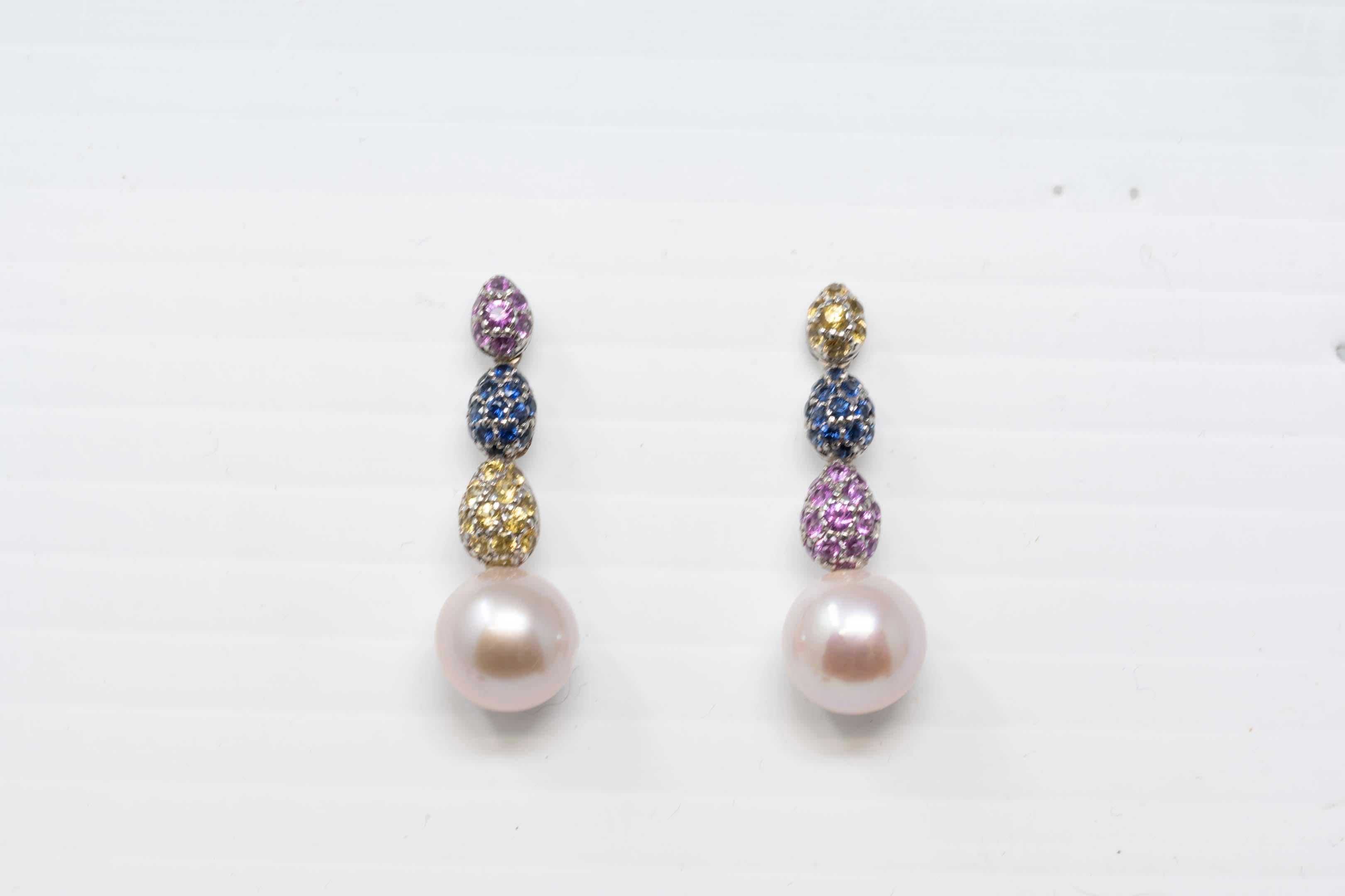 18k white gold earring set with 36 corundum sapphire gemstones pink color, yellow and blue with a cultured pearl measuring 11mm in diameter, about 33mm long. Made in Canada, stamped on the back, 750 and maker SPD (SP Diament Jewels). In good