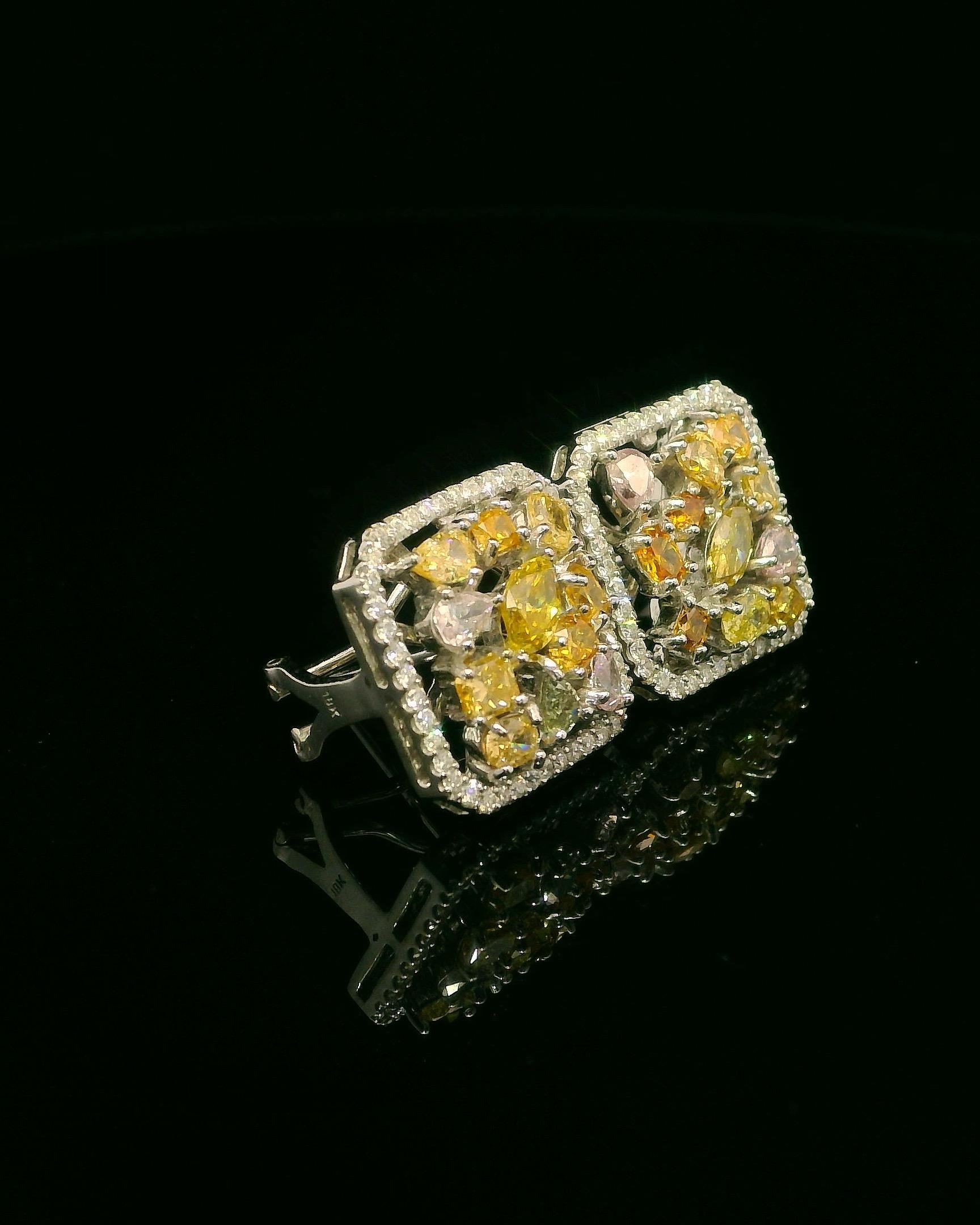 A dazzling celebration of rarity and refinement, this exquisite pair of 18K white gold earrings features a curated collection of 11 unique fancy color diamonds, totaling approximately 1 carat. Each diamond—ranging in vibrant hues of orange, pink,