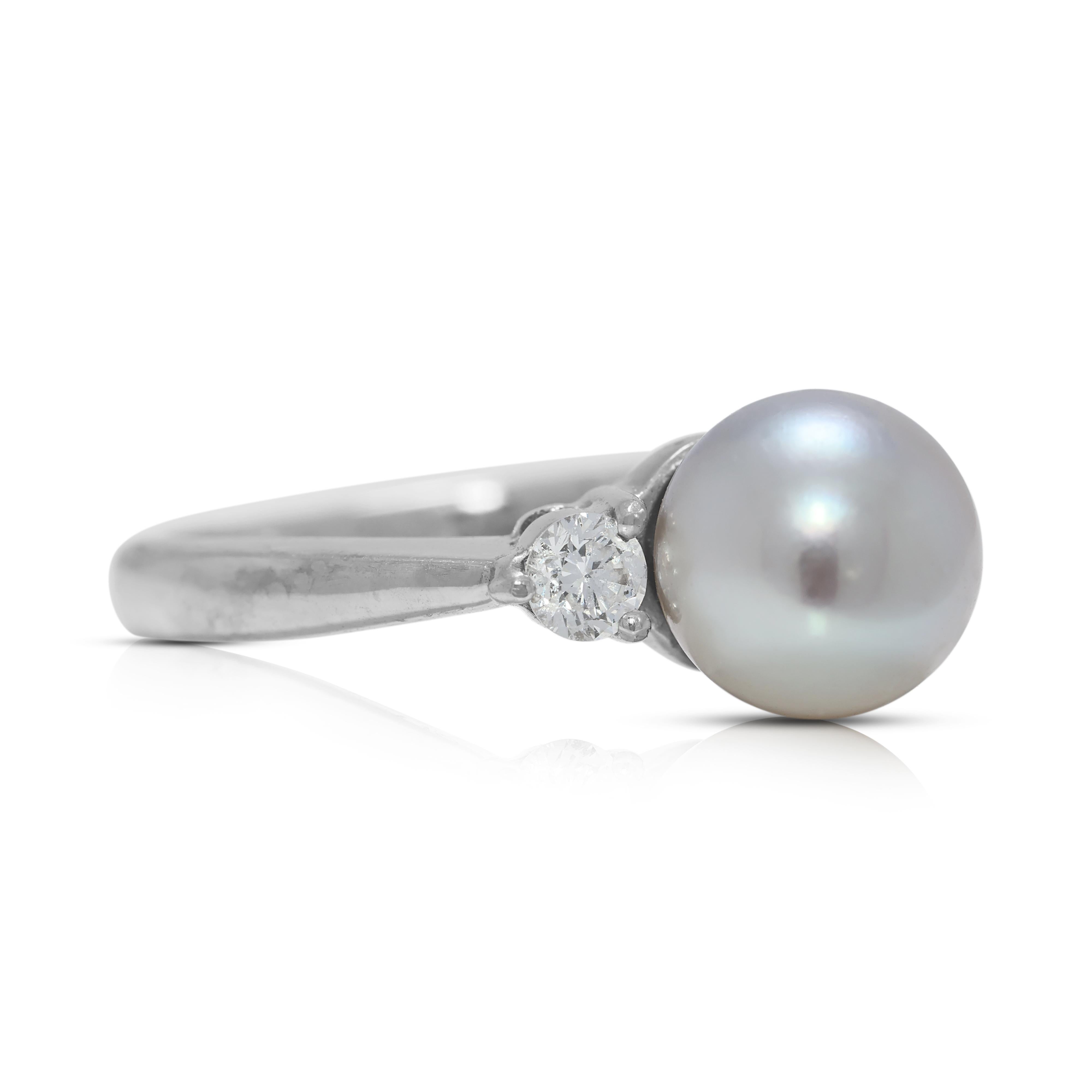Im Herzen des Rings liegt eine schimmernde Perle, ein Symbol für Reinheit und zeitlose Schönheit. Diese Perle, die oft von hervorragender Qualität ist, bildet das Herzstück des Rings und strahlt ihr natürliches Schillern und ihre sanfte Eleganz aus.