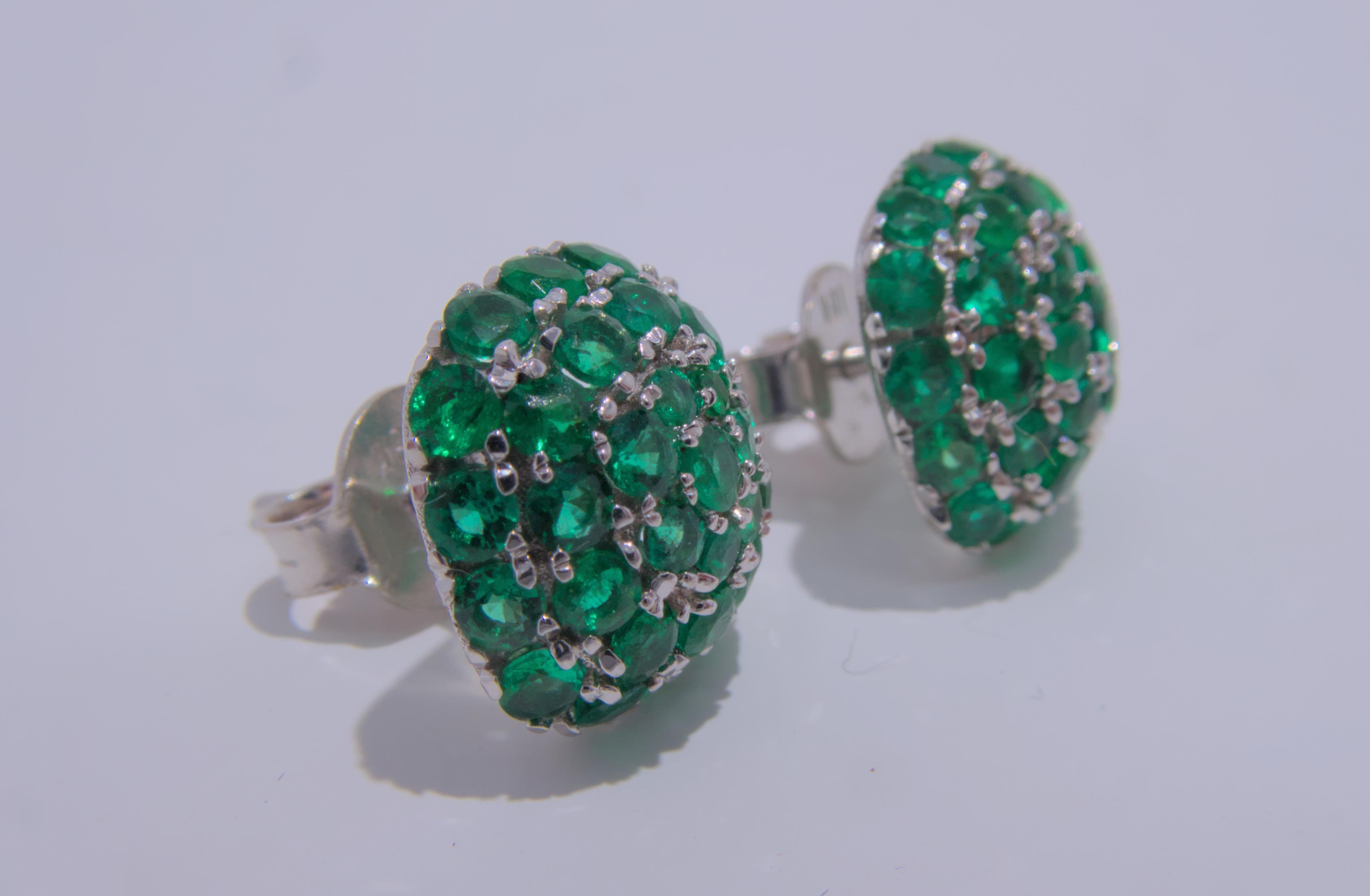 These stunning 18K white gold cluster earrings, designed by Chun Yi, feature a beautiful array of brilliant round emeralds. The total estimated weight of the emeralds is an impressive 1.88 carats, adding a pop of color and a touch of luxury to the
