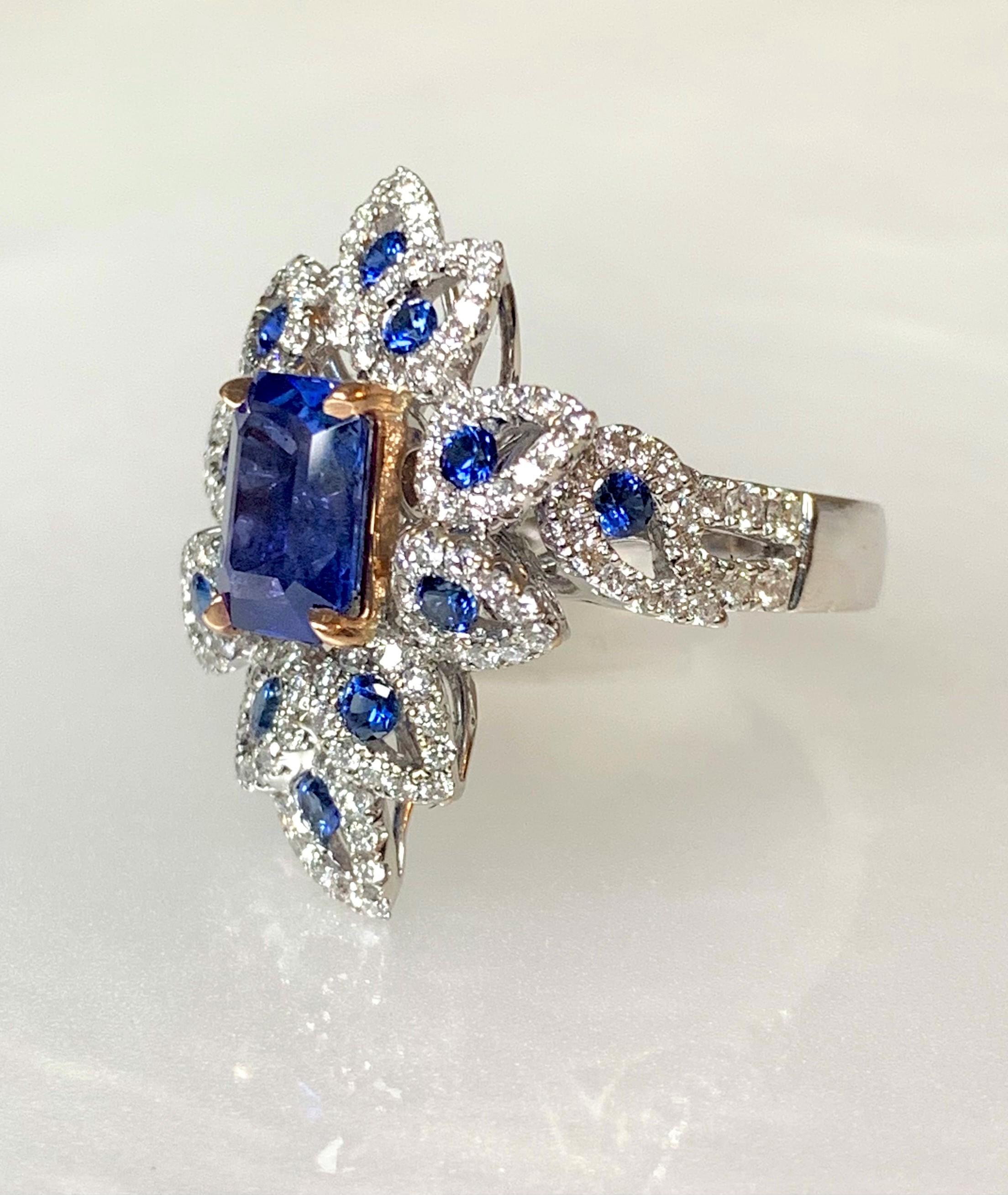 An exceptional piece with meticulous detailing to add to your fine jewelry collection. Here is an 18k white gold one of a kind richly saturated blue sapphire ring featuring a 3.17 carat emerald- cut center stone set in rose gold prongs, surrounded