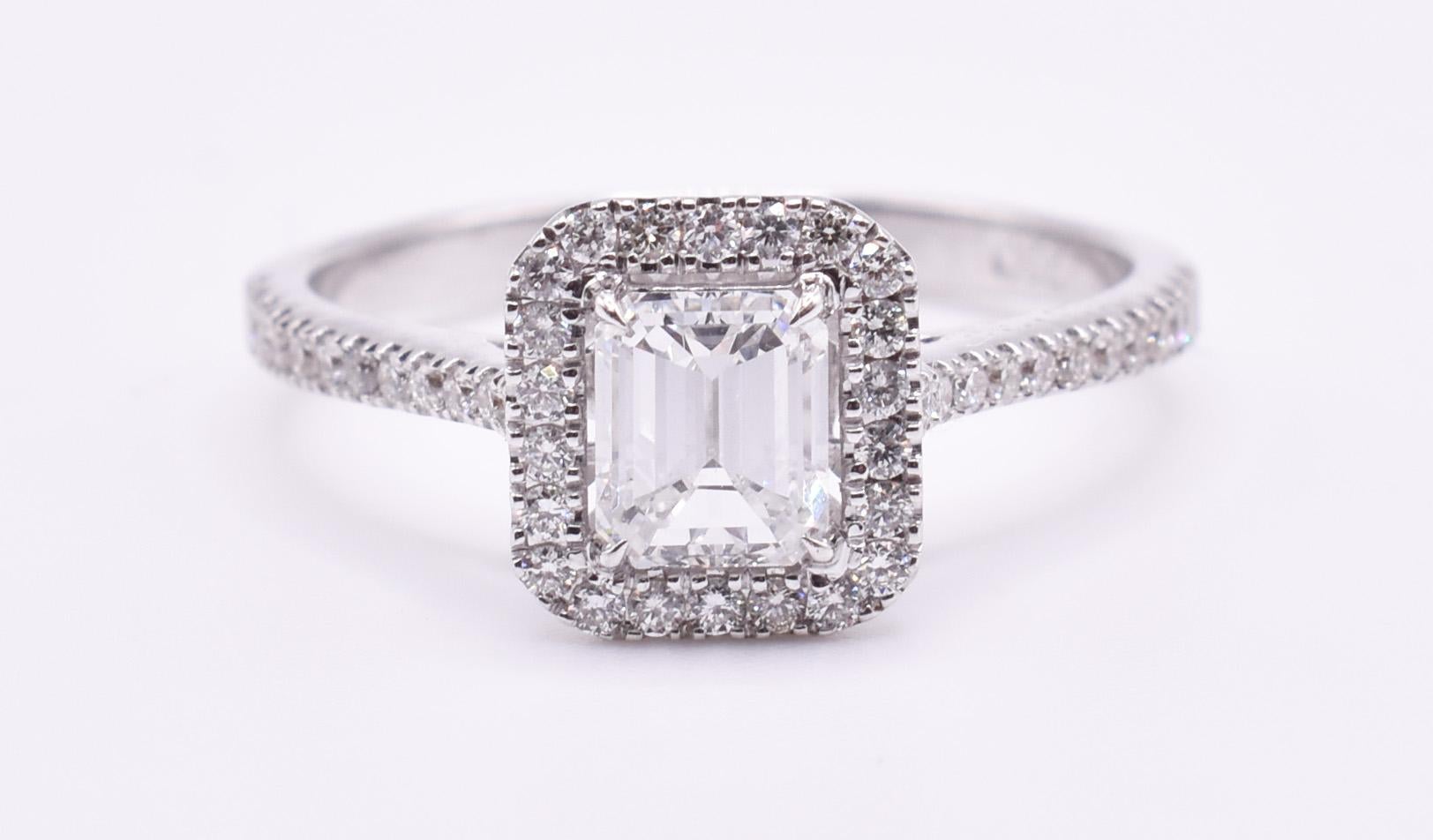 For sale is a fine quality 18k white gold diamond engagement ring, featuring a 0.66ct emerald cut diamond to the centre, with a halo surround and pavé sides to the shank, adding a further 0.30ct of diamonds. 

Metal: 18k White Gold
Total Carat