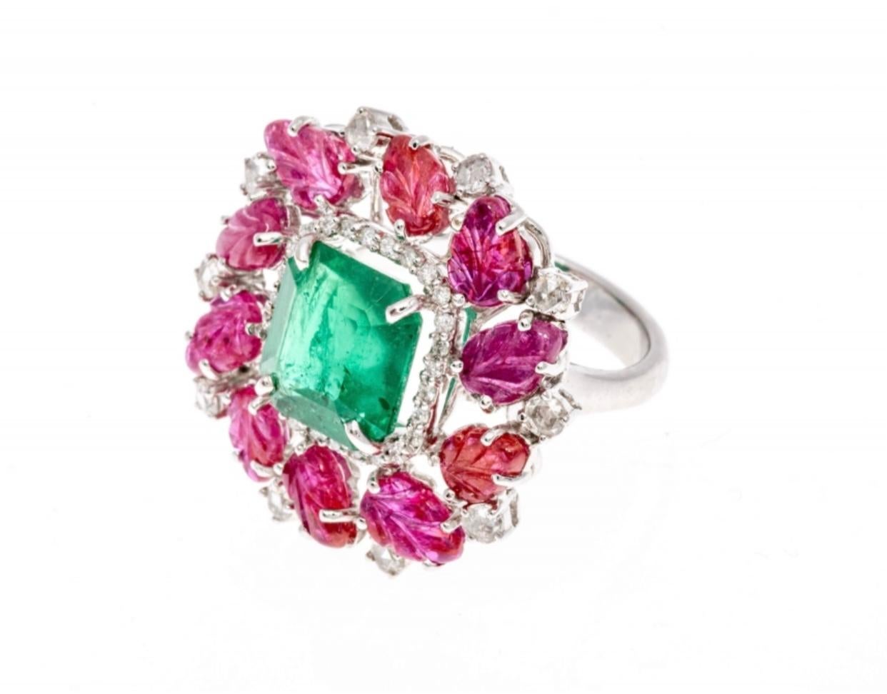 This gorgeous ring contains a center emerald cut faceted, clear medium to light green emerald, approximately 3.65 CTS, surrounded by round faceted diamonds, approximately 0.007 TCW and prong set. Surrounding the center emerald and diamonds, is a