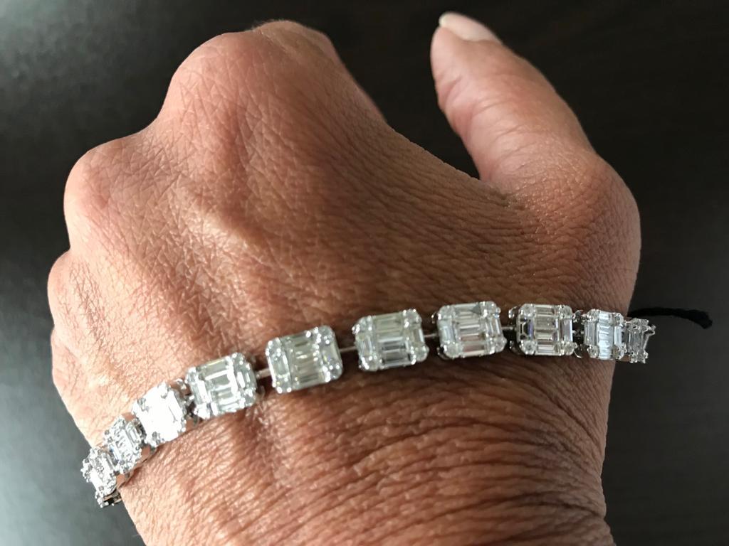 Emerald cut bracelet set in 18K white gold. The stones are a cluster of baguette and round diamonds that create the illusion of a single emerald. The bracelet weighs a total of 8.45 Carats. The color and clarity of the stones are F color, VS1-VS2