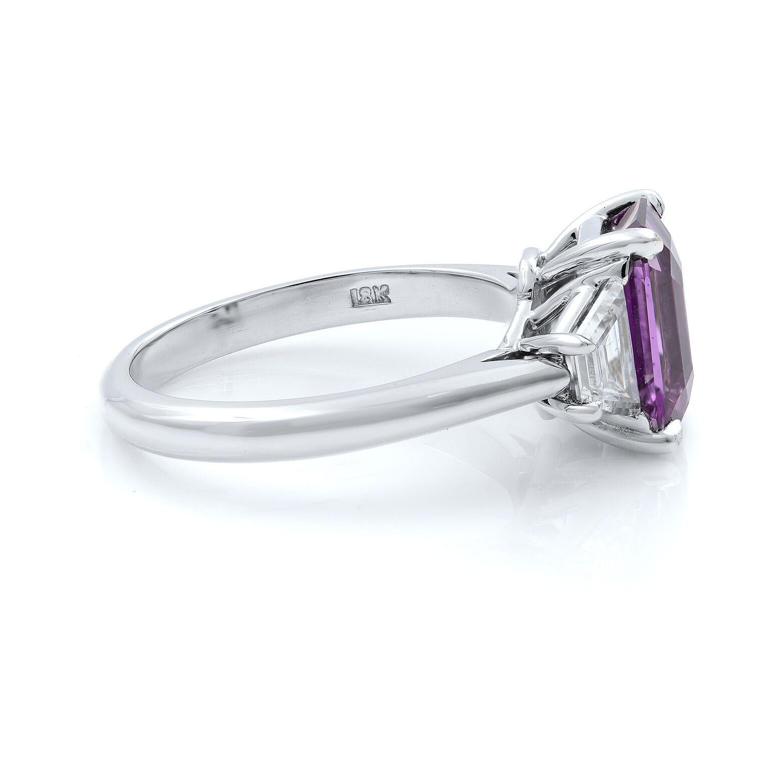 A beautiful 18k white gold pink sapphire emerald cut and trapezoid cut diamonds engagement ring. The stones are set with 4 prong setting. Total carat weight: 3.34 cts. The emerald weighs 2.75cts and two trapezoid are 0.59cts. Ring size 7. GIA