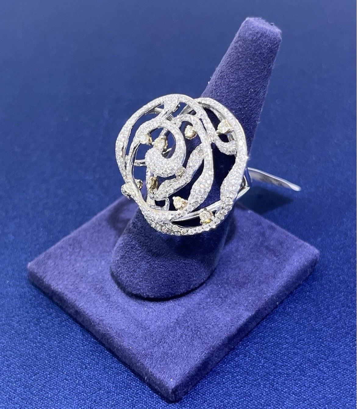 Exprimez un glamour intemporel avec cette exquise bague de cocktail en or blanc 18 carats, ornée d'environ 3 carats de diamants ronds et brillants étincelants. Conçue dans un élégant motif floral et tourbillonnant, cette pièce allie magnifiquement