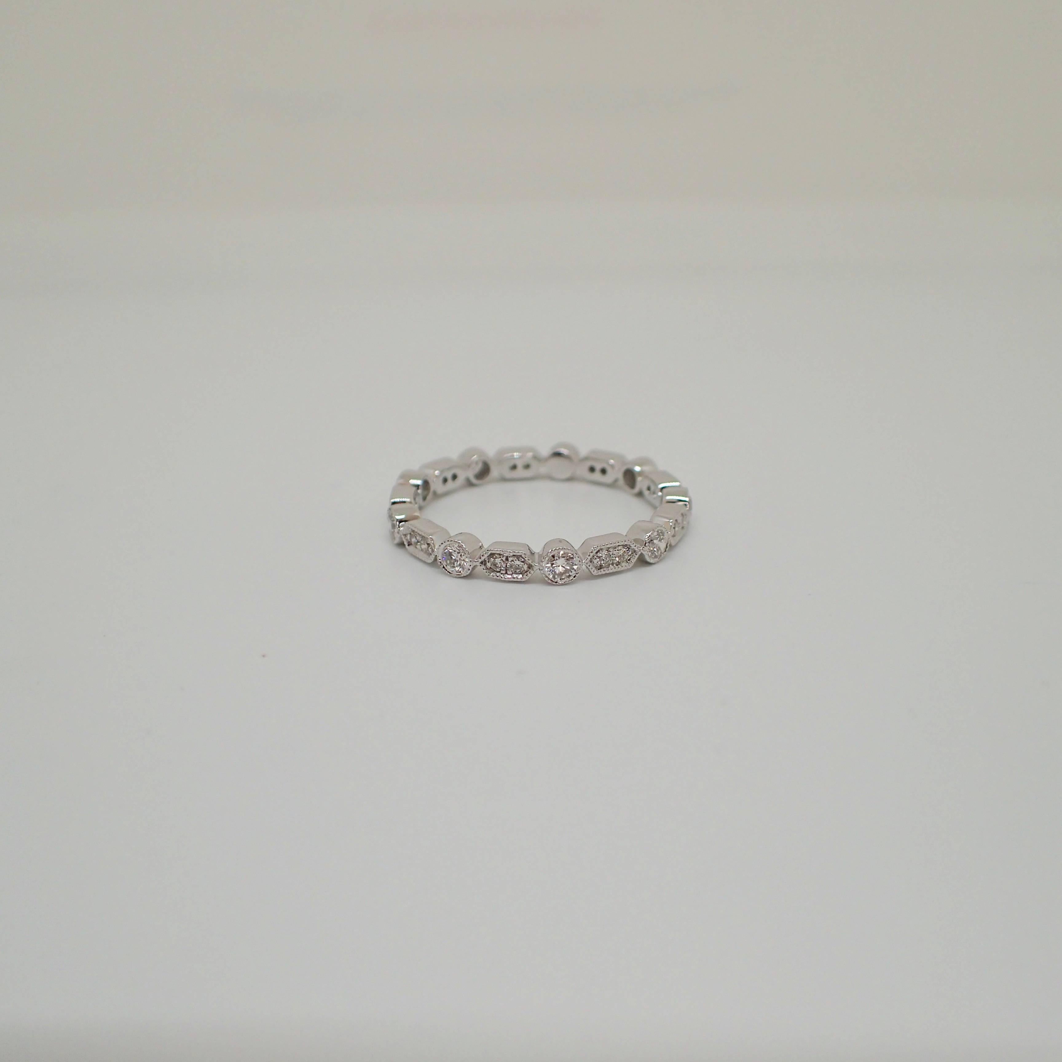 One (1) 18k White Gold eternity band contains twenty-seven (27) Round Brilliant Cut diamonds that weigh a total of 0.44 carats with Clarity Grade VS with Color Grade G, nine (9) of the diamonds are bezel set and eighteen (18) of the diamonds are